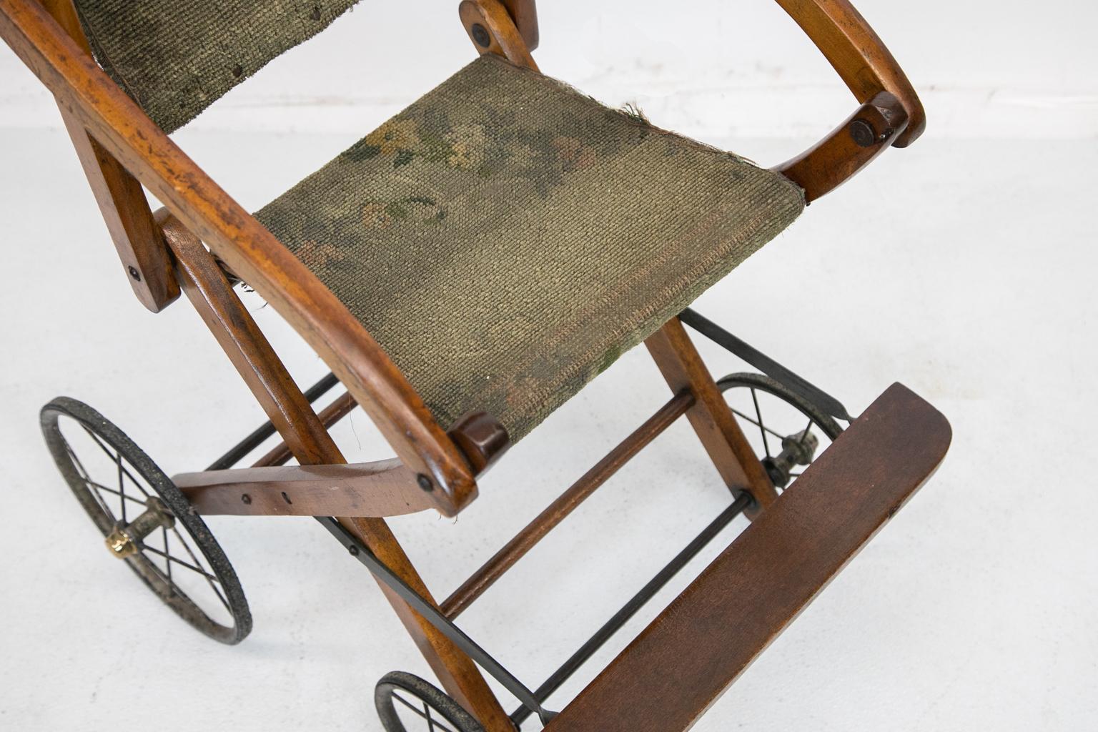 Antique English stroller has the original wire wheels with brass lugs and the original fabric seat. The back is commensurate with use and age. We purchased it on one of our buying trips to England and thought it was unique as we have never seen