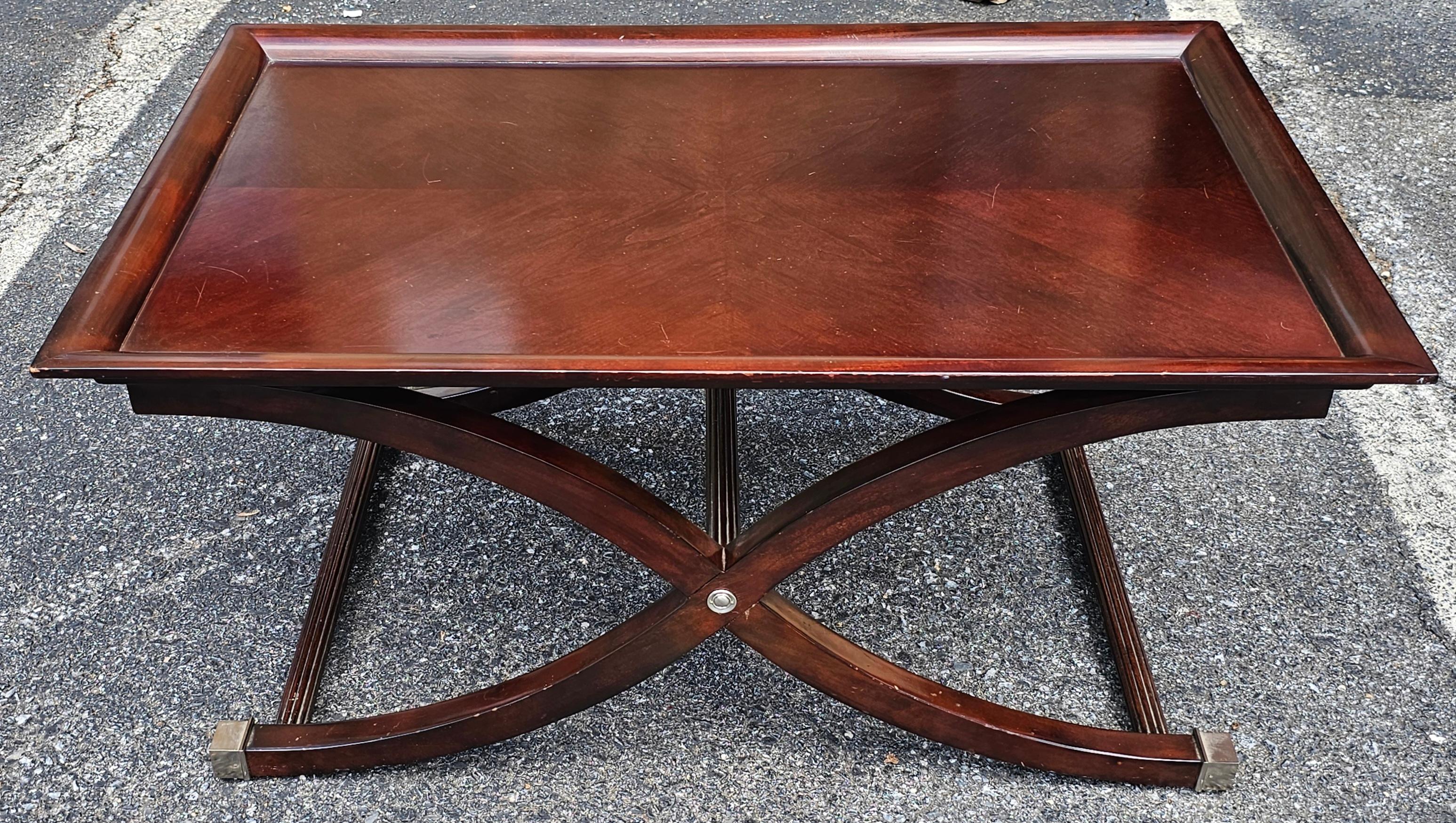 Contemporary Stained Fruitwood Coffee Table Referencing an antique English style with tray table top supported by graceful curved x-base that are finished in metal toe caps. 
Measures 42
