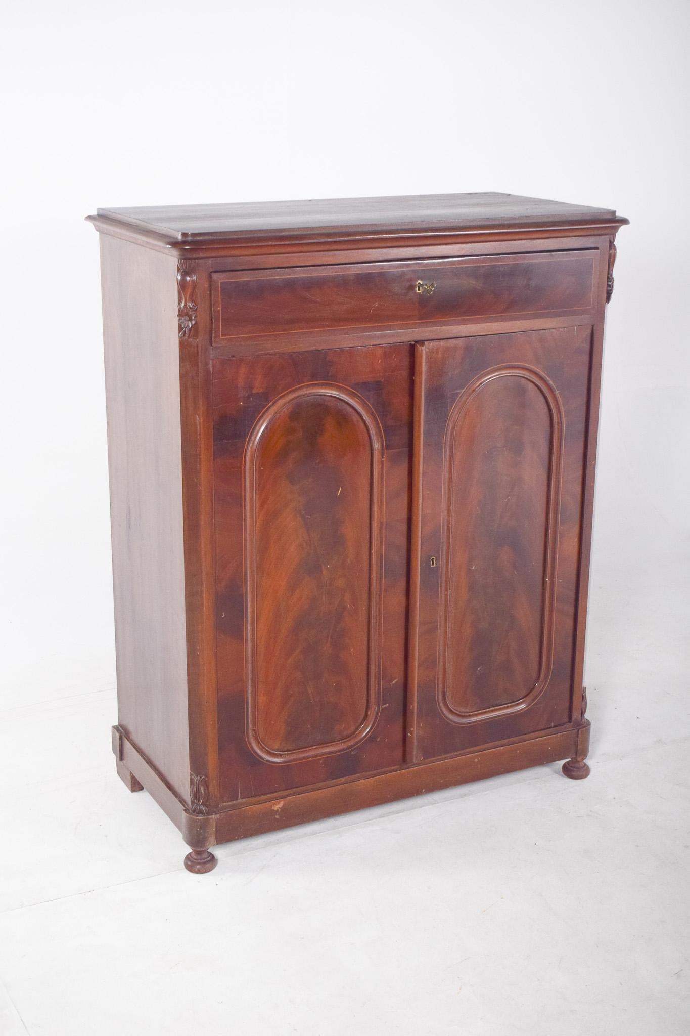 Tall, antique cabinet. With a classic design, it has details worked in high relief on the doors and sides, giving it a distinctive character. The lower part consists of two doors that open to reveal three internal shelves, ideal for storing dishes,