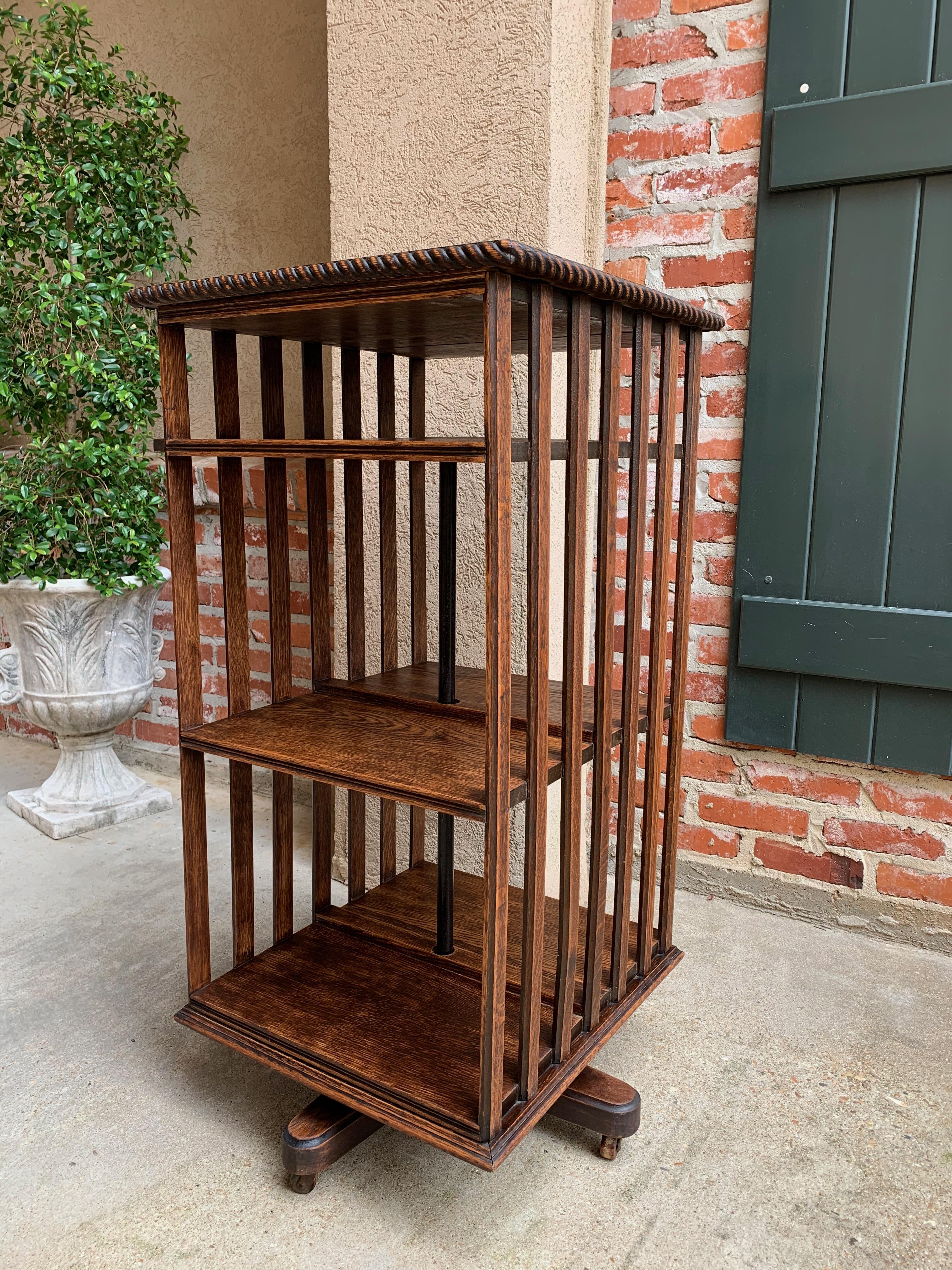 Direct from England, a Classic antique English oak revolving bookcase that both rolls and revolves~
~Slatted panels on each side provide a Classic Arts & Crafts era style~
~Stunning tiger oak grain; carved rope trim on the top edges~
~Extra tall