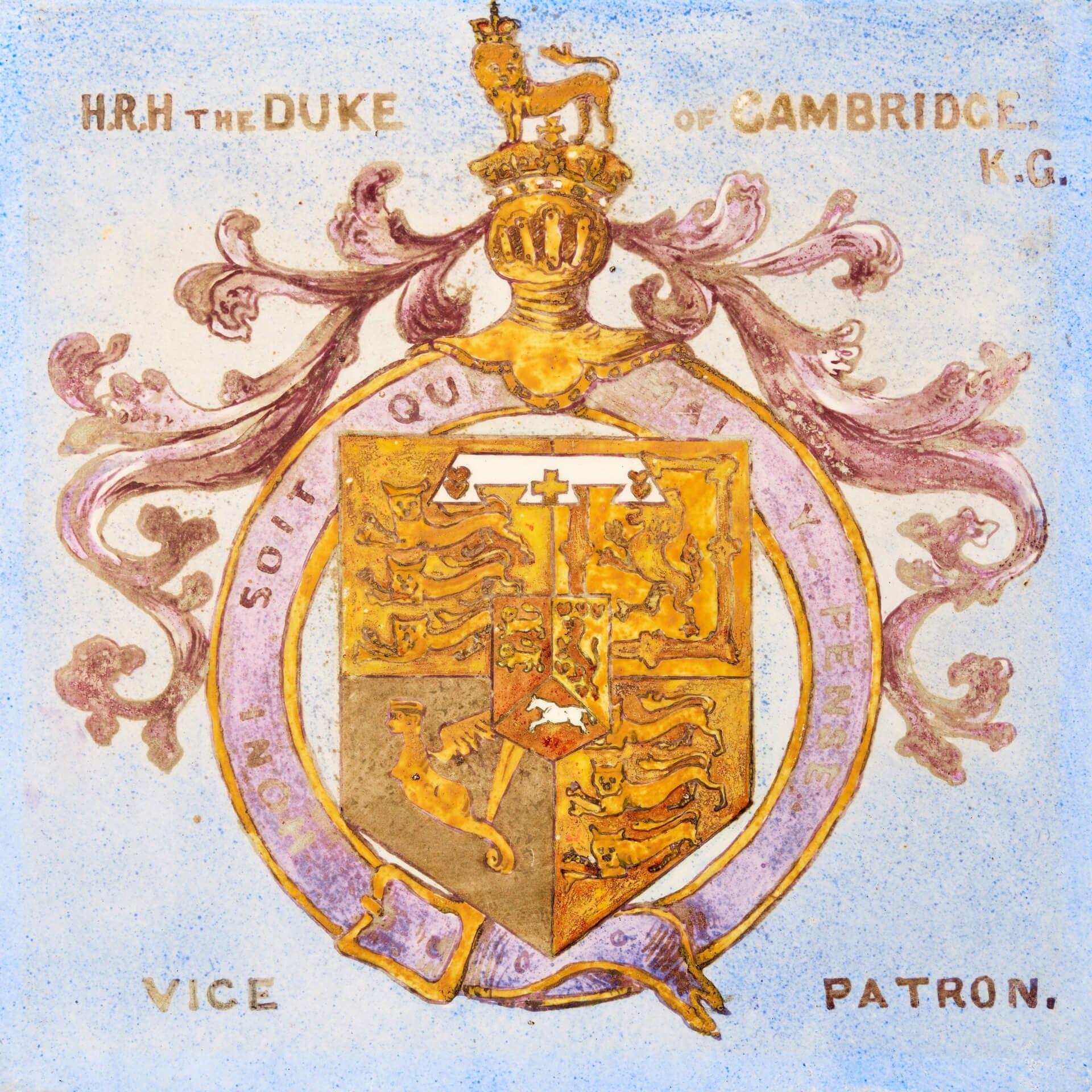 A hand decorated antique English heraldic tile depicting the coat of arms of Prince George, Duke of Cambridge, dating from 1881. This porcelain tile is one of 14 similar we are selling, removed from the now demolished library of the Victorian