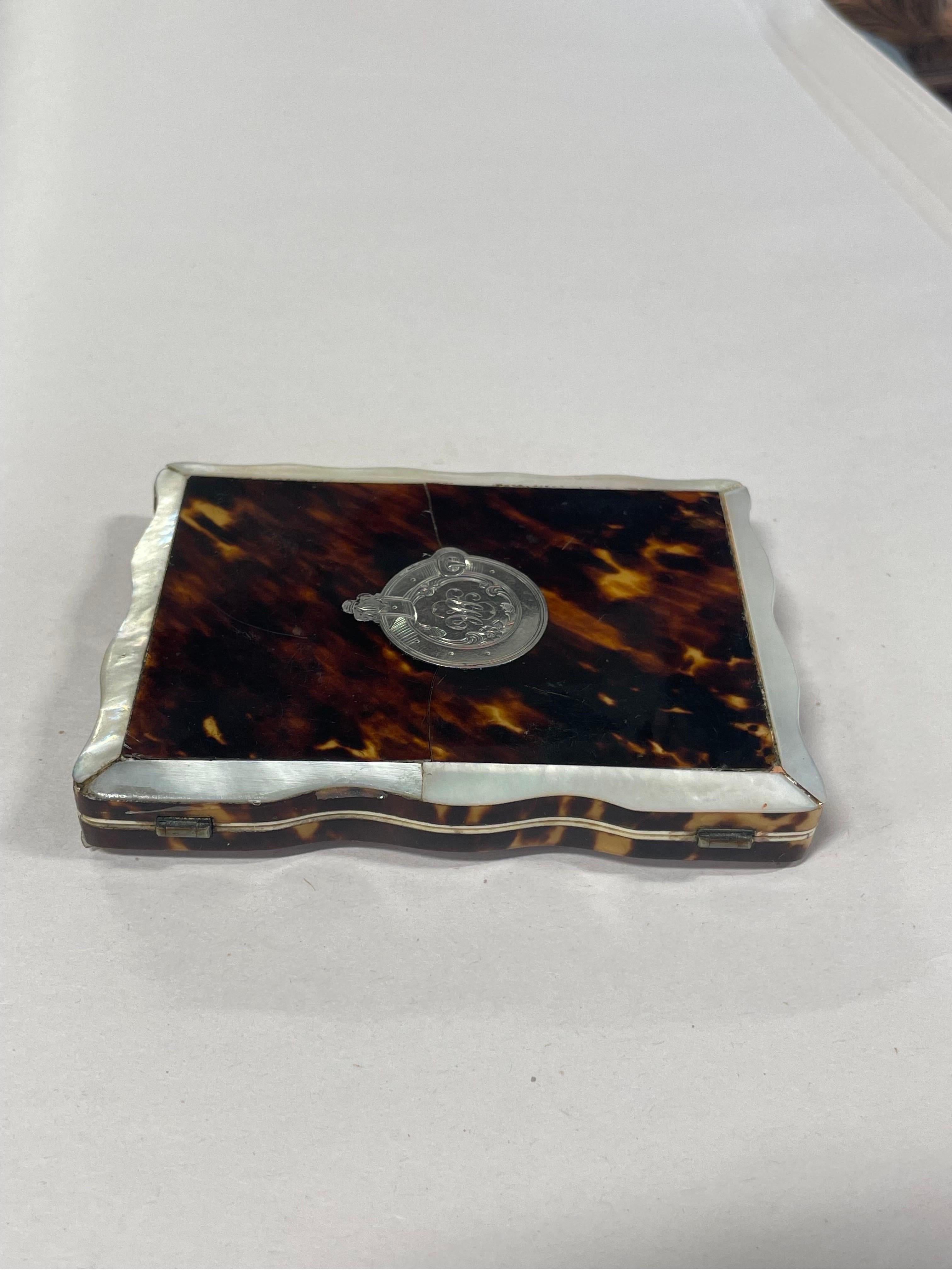 An antique english card case holder constructed from tortoiseshell, mother of pearl and sterling silver.