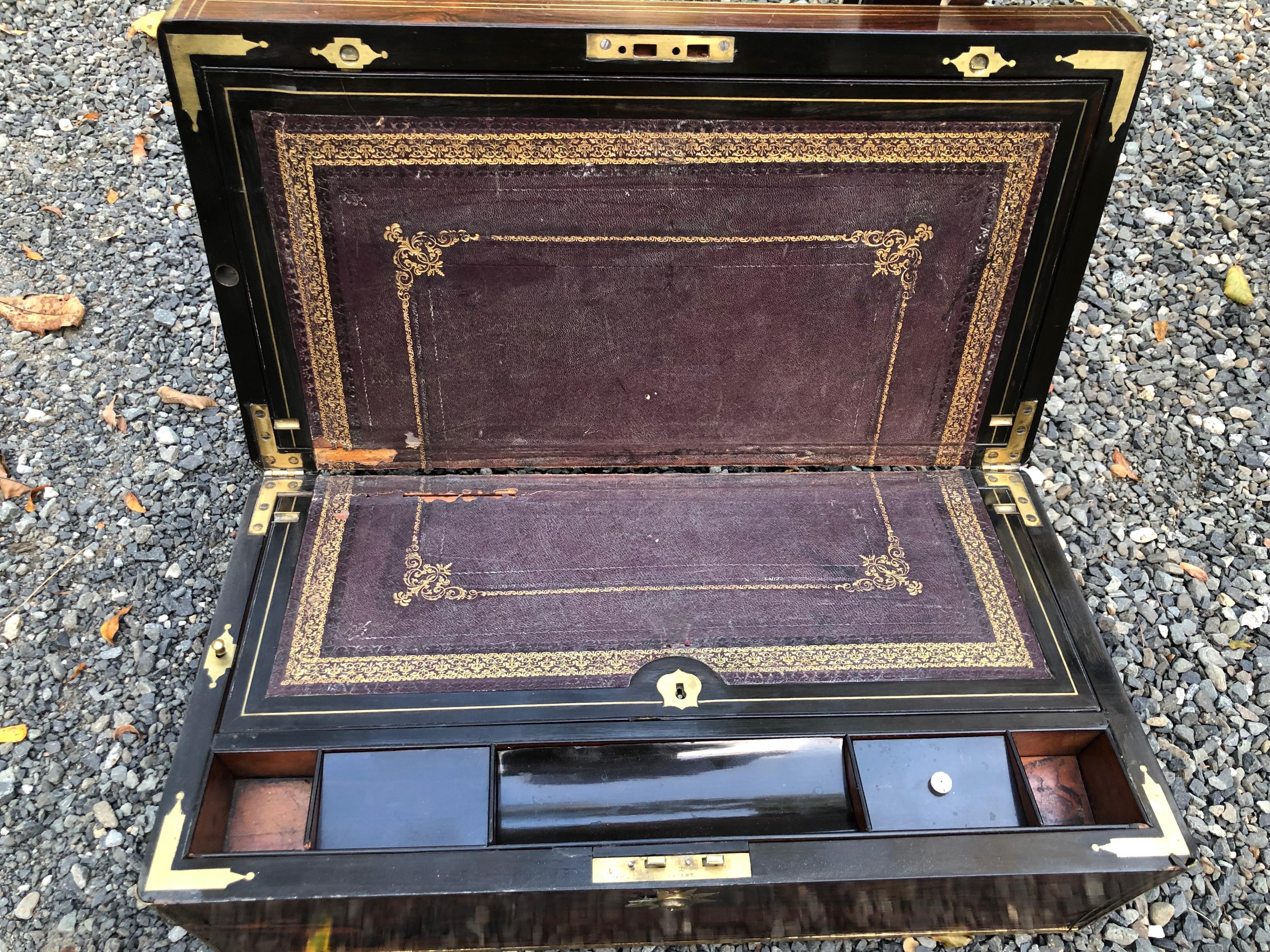 English mahogany lap desk, brass bound with inlaid brass stringing and brass presentation plaque. There are compartments for ink wells, writing instruments and paper. The custom stand, made approximately 30 years ago, is mahogany with fretwork under