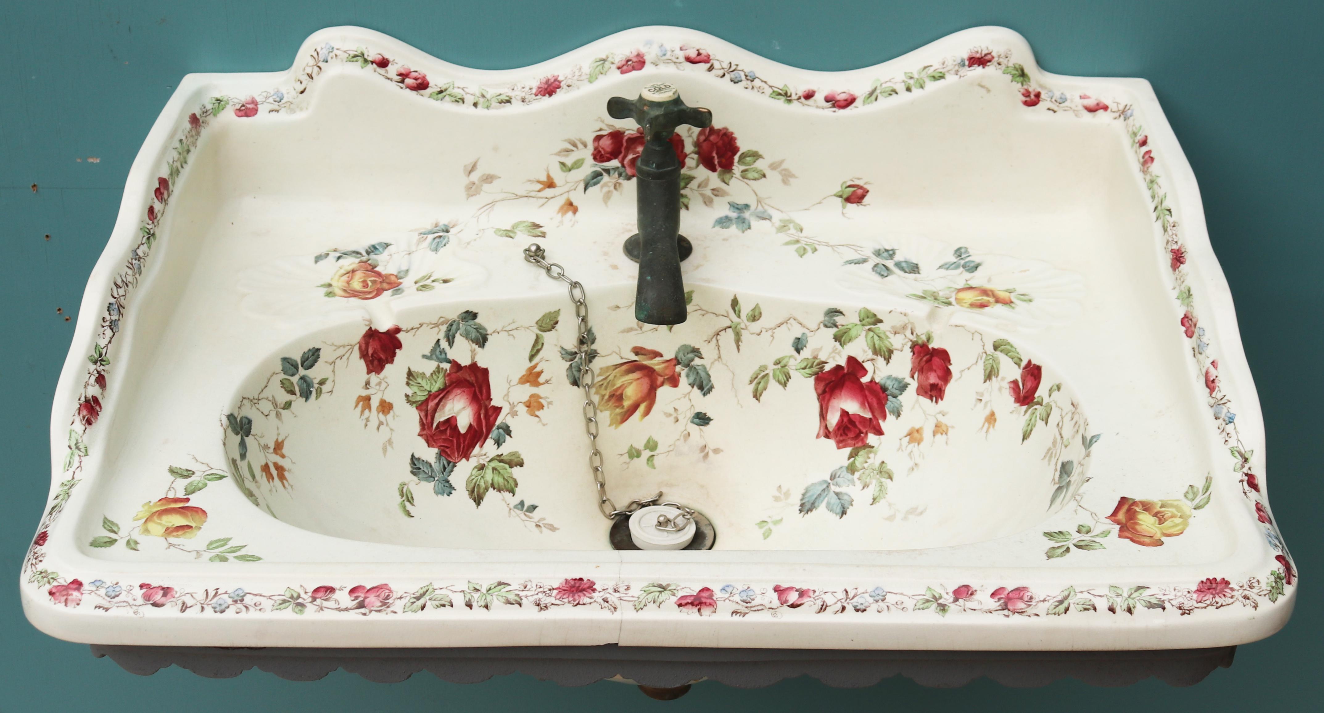 Une vasque à décor floral récupérée, fournie avec un support mural original en fonte.