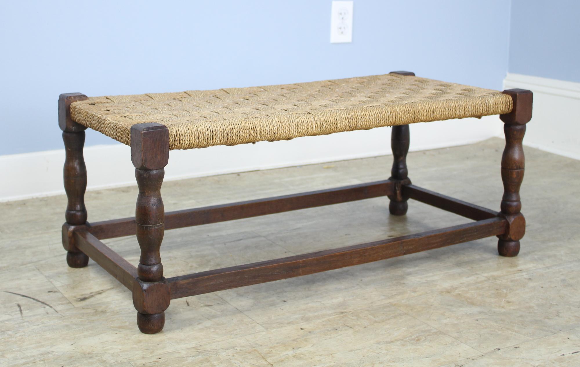 A sweet little oak string stool for the hallway, living room, child's bedroom, or as a perch next to the fireplace. The turned legs complete the look! Note: there is a small area of wear on the inside of one of the legs, as shown in image #7.