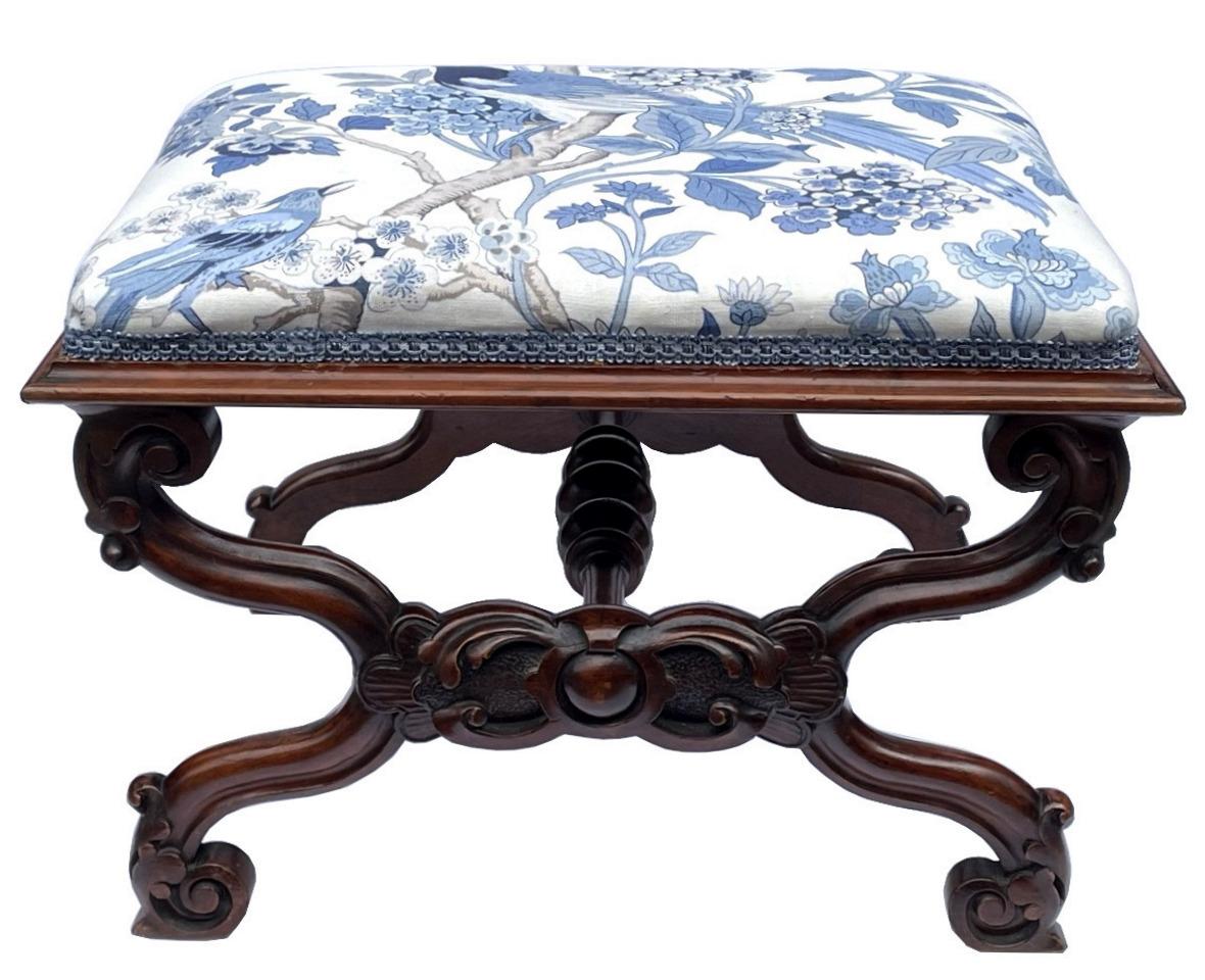 Stylish hand carved Victorian mahogany upholstered stool of rectangular form and of English origin. circa 1840-1850. 

Constructed in figured mahogany, the rectangular seat above an attractive hand carved mahogany cross-stretcher frame support,