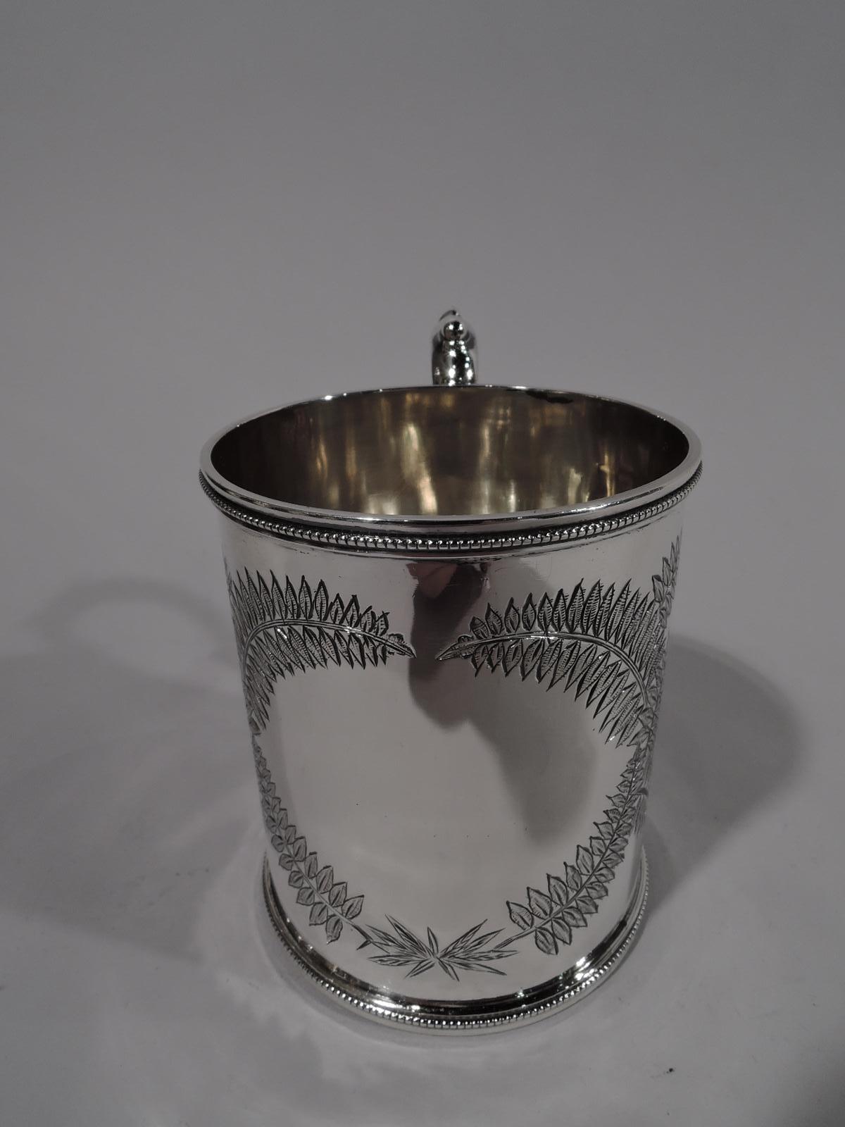 Victorian Aesthetic sterling silver baby cup. Made by George R. Unite in Birmingham in 1877. Straight sides, and molded rim and foot inset with beading. Capped double-scroll handle with graduated beading. On body are engraved fronds forming two