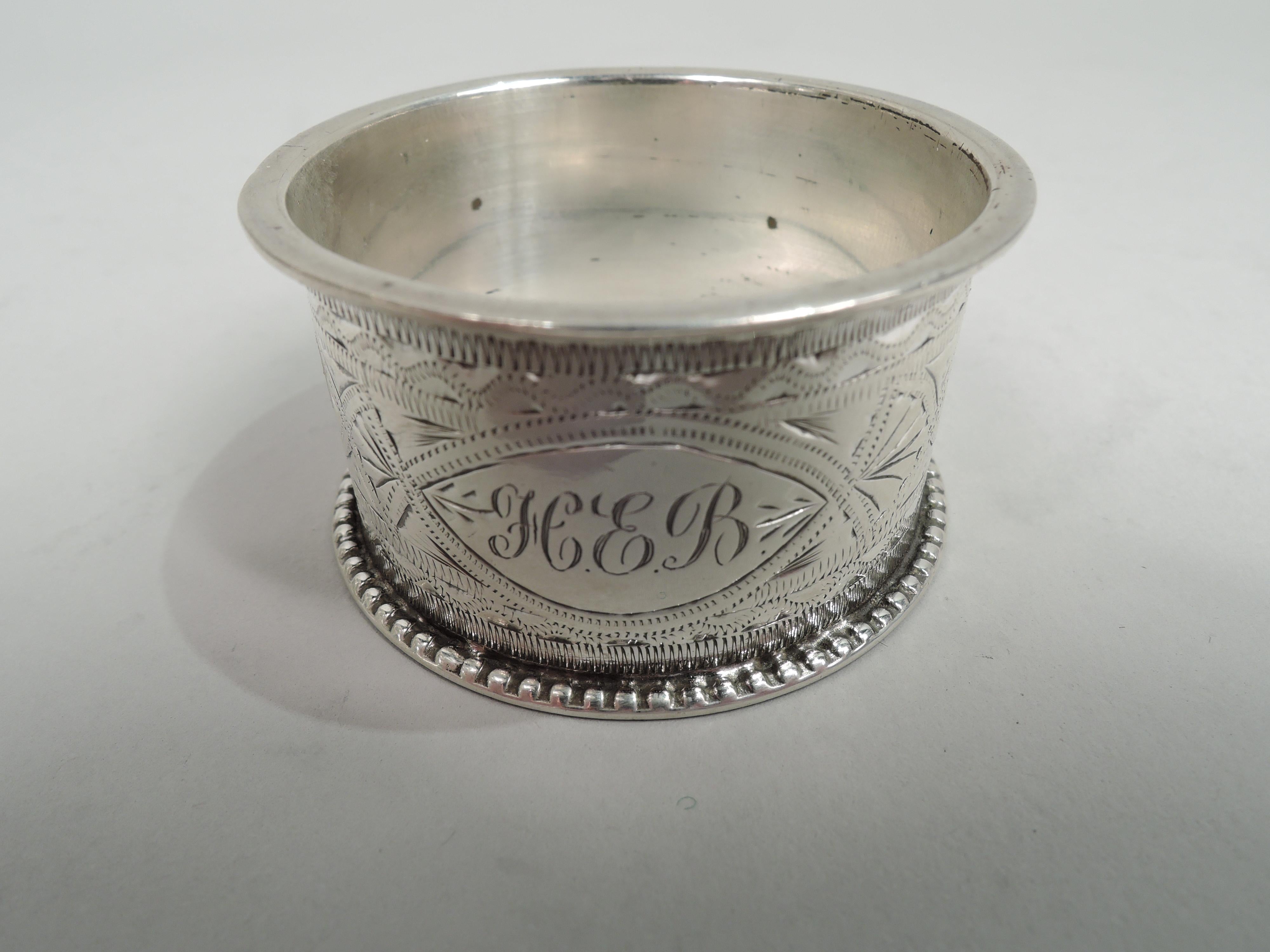 English Victorian Aesthetic sterling silver napkin ring, 1897. Retailed by T. Beardmore in Birmingham. Bright-cut stylized ornament: Guilloche border inset with flower heads between zigzag and wavy borders. Beaded rims. Fully marked.