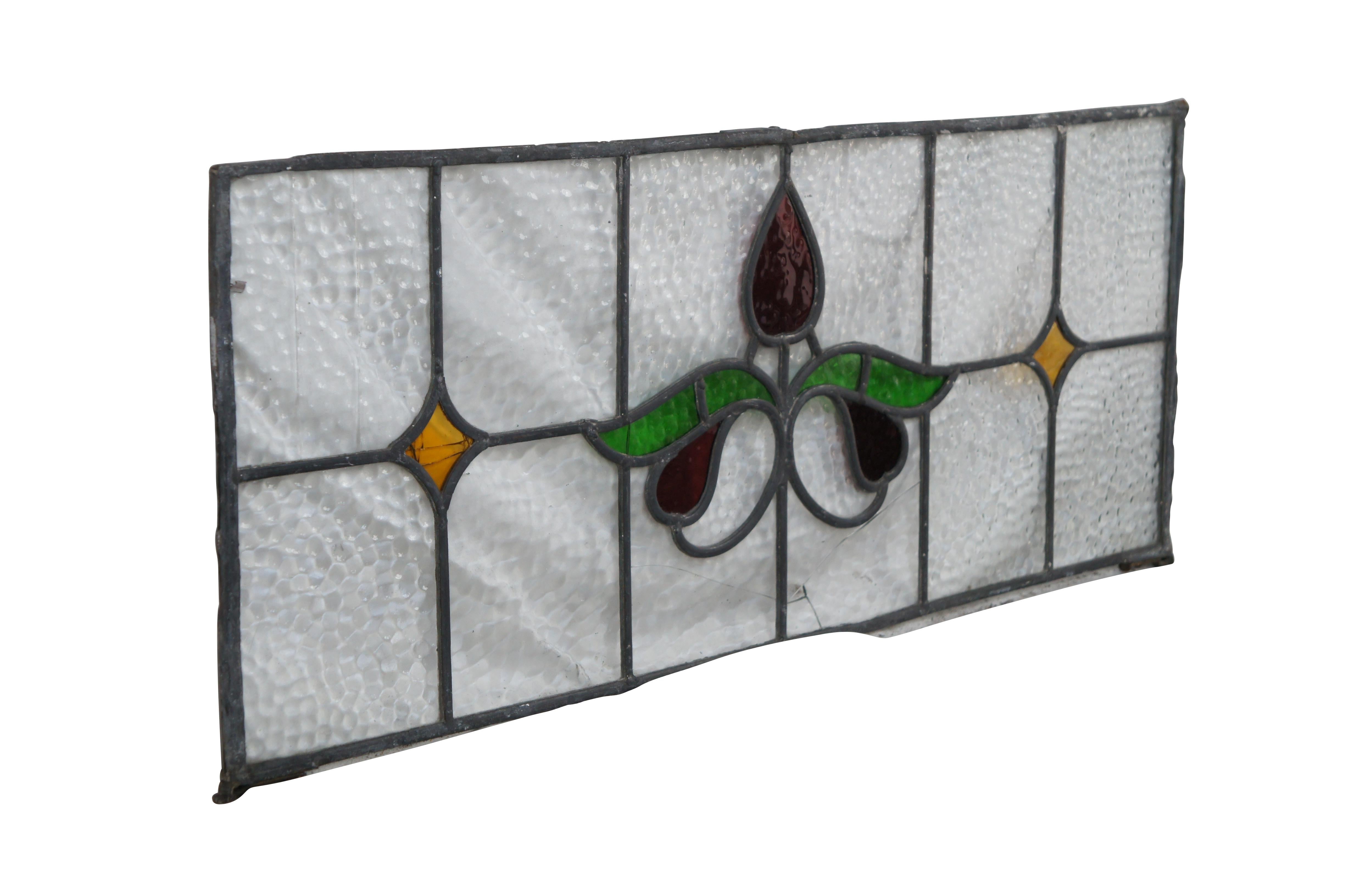 Magnifique vitrail ancien au plomb de style Art Nouveau. Le centre est orné d'un motif floral dans un ton rubis avec des feuilles vertes flanquées de diamants de couleur ambre et d'un fond de verre galbé. Parfait pour une utilisation au-dessus d'une