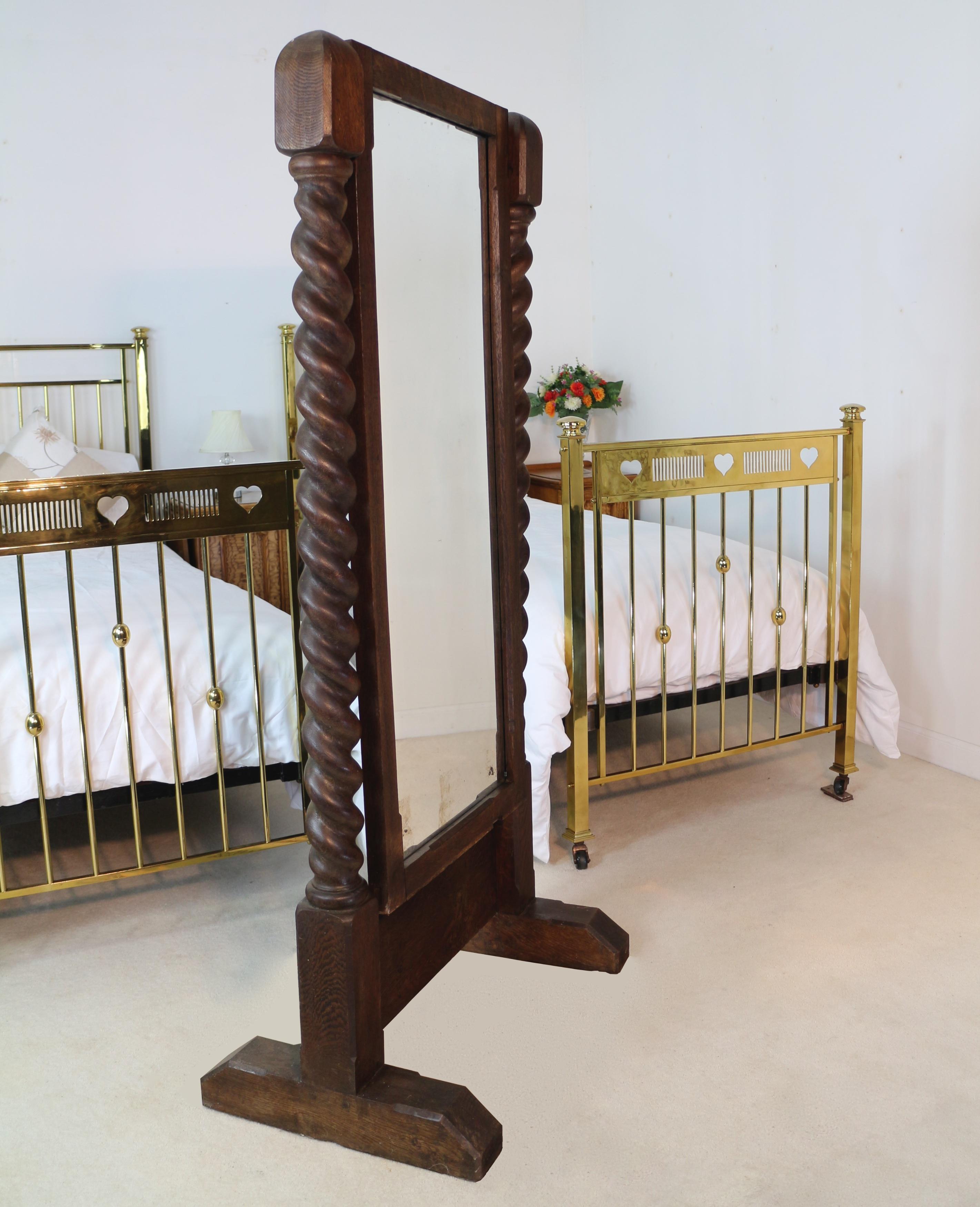 An unusual Victorian oak cheval mirror with barley twist columns and on shaped plinth supports, the chamfered edges to the finials, base and mirror frame give a distinct Arts & Crafts feel. In good condition with original colour and some quarter