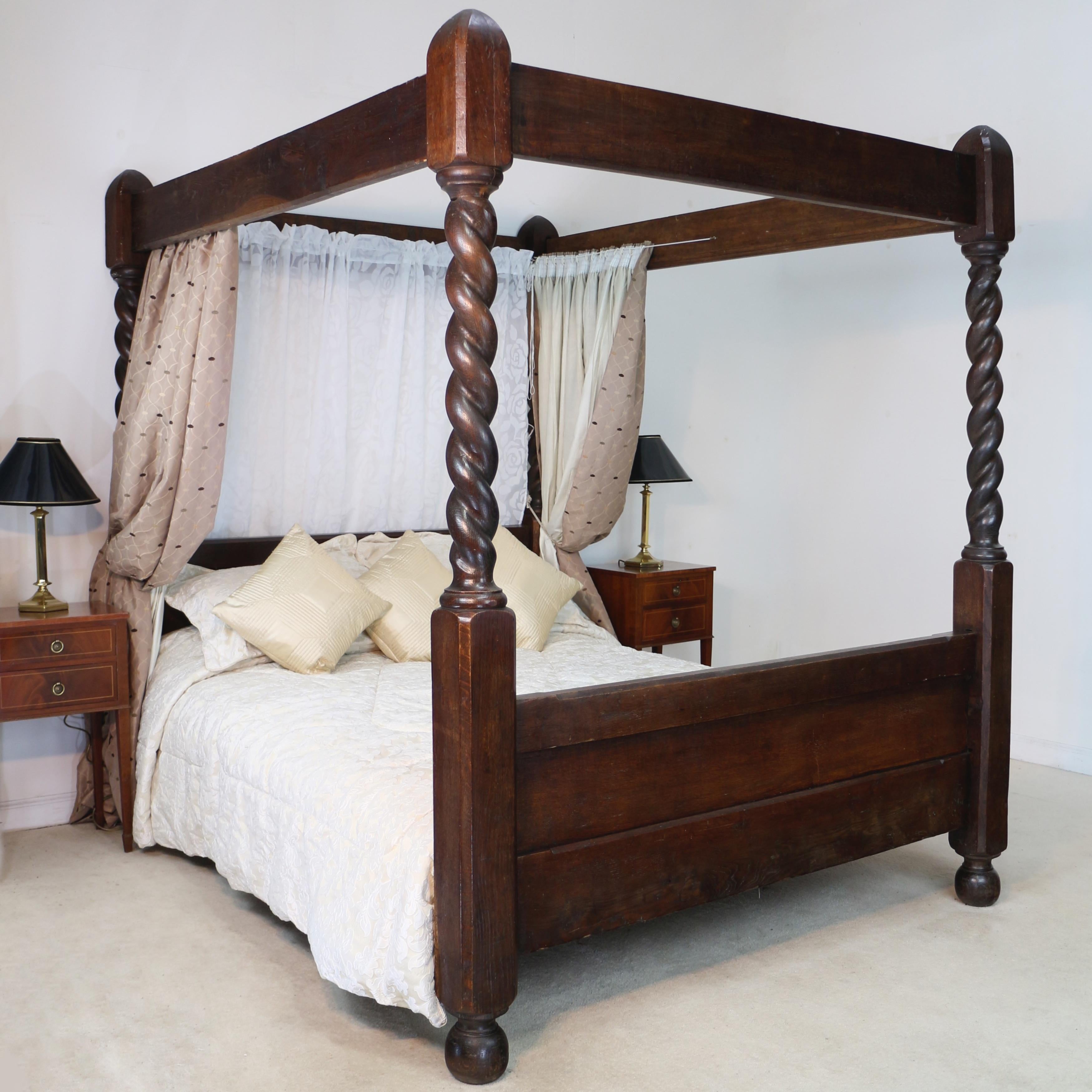 A rare Victorian oak four poster bed with barley twist columns to the head and foot. Chamfered edges give an Arts & Crafts feel and it stands on flattened bun feet. Comes with a slatted base to support a mattress. In good condition it does have some