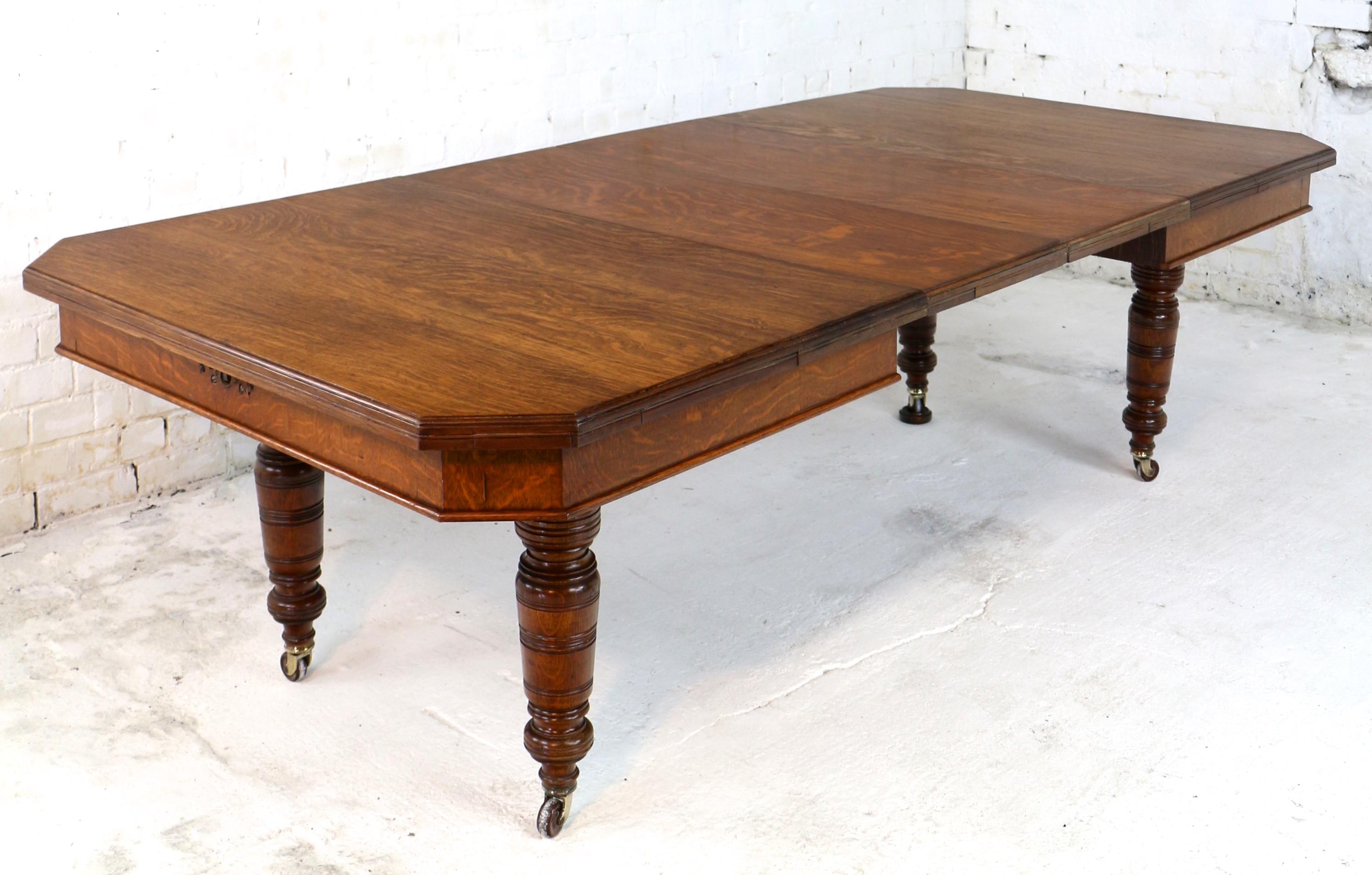 A super late Victorian wind-out extending dining table in quarter-sawn oak with two original leaves and dating to circa 1880. In the Arts & Crafts taste it has a rectangular top with canted corners and a moulded edge and stands on four ring-turned