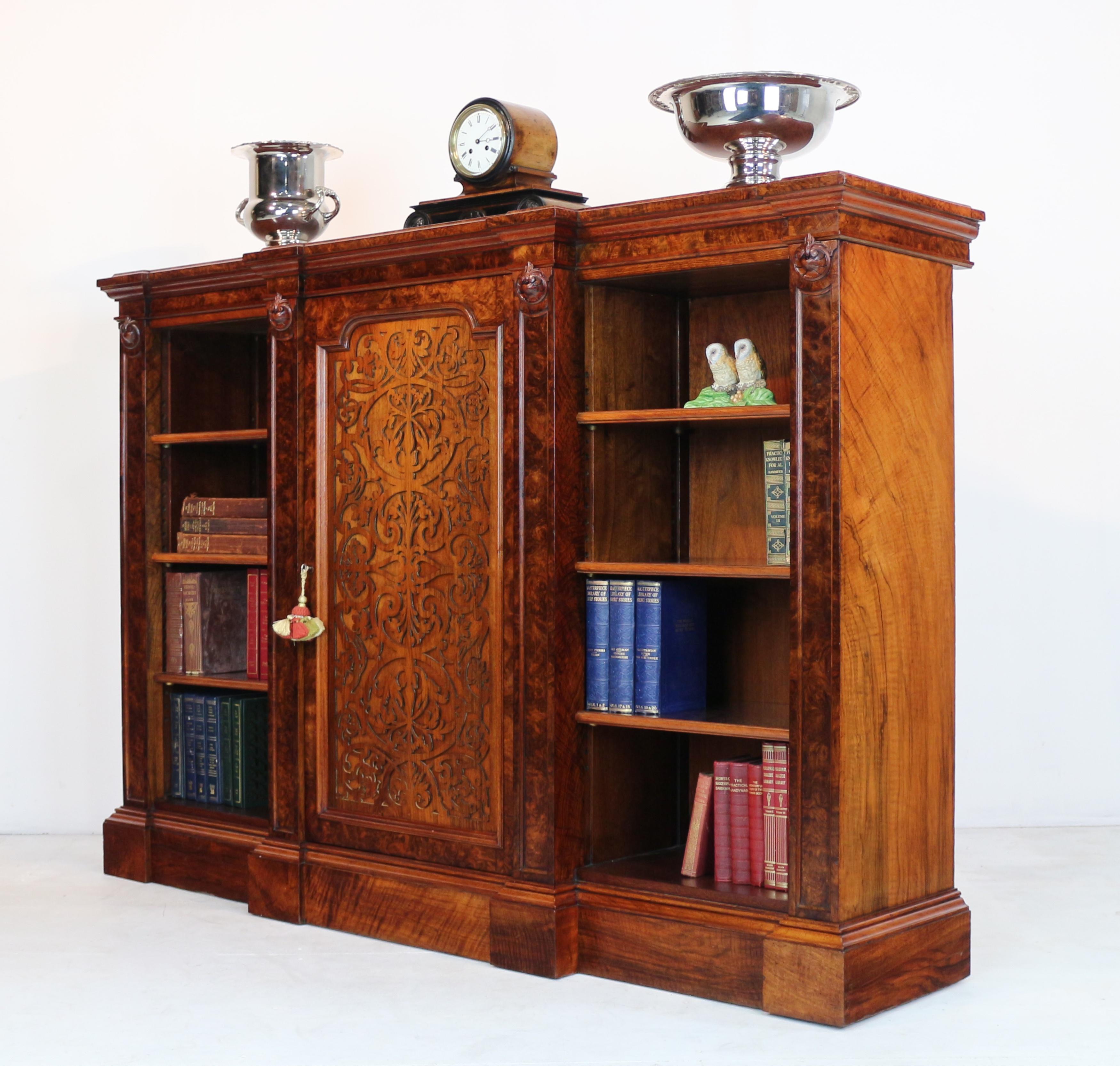 Super Victorian burr walnut breakfront bookcase or side cabinet, circa 1850, of fine quality with a double moulded top above a frieze with carved roundels and fielded panels to the pilasters and a central cupboard door with arabesque pattern blind