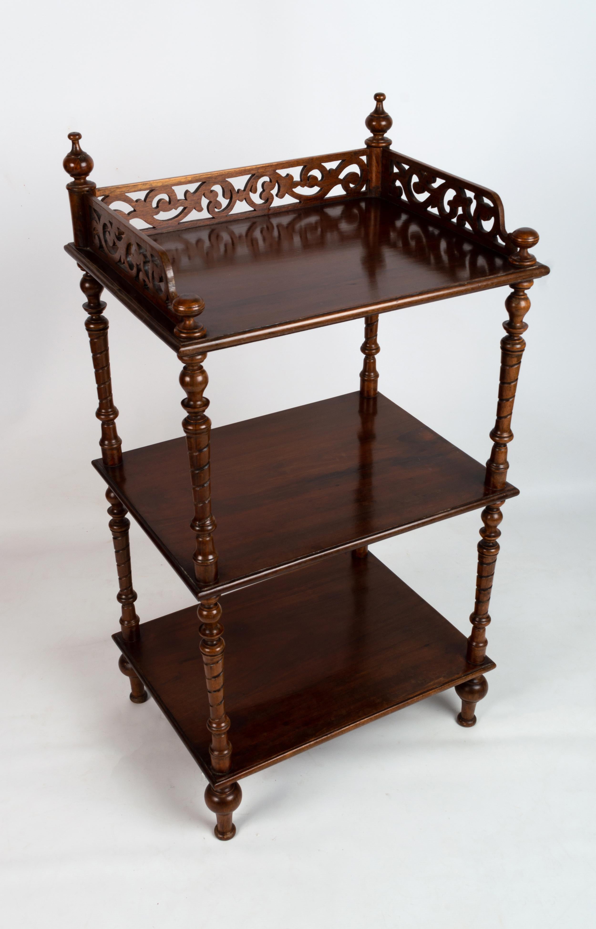 Antique English Victorian carved mahogany whatnot Etagere C.1880

A late Victorian mahogany whatnot, of three open tiers, with finials, a fret carved three quarter gallery, twist carved columns, on turned feet and castors.

A superb example, in
