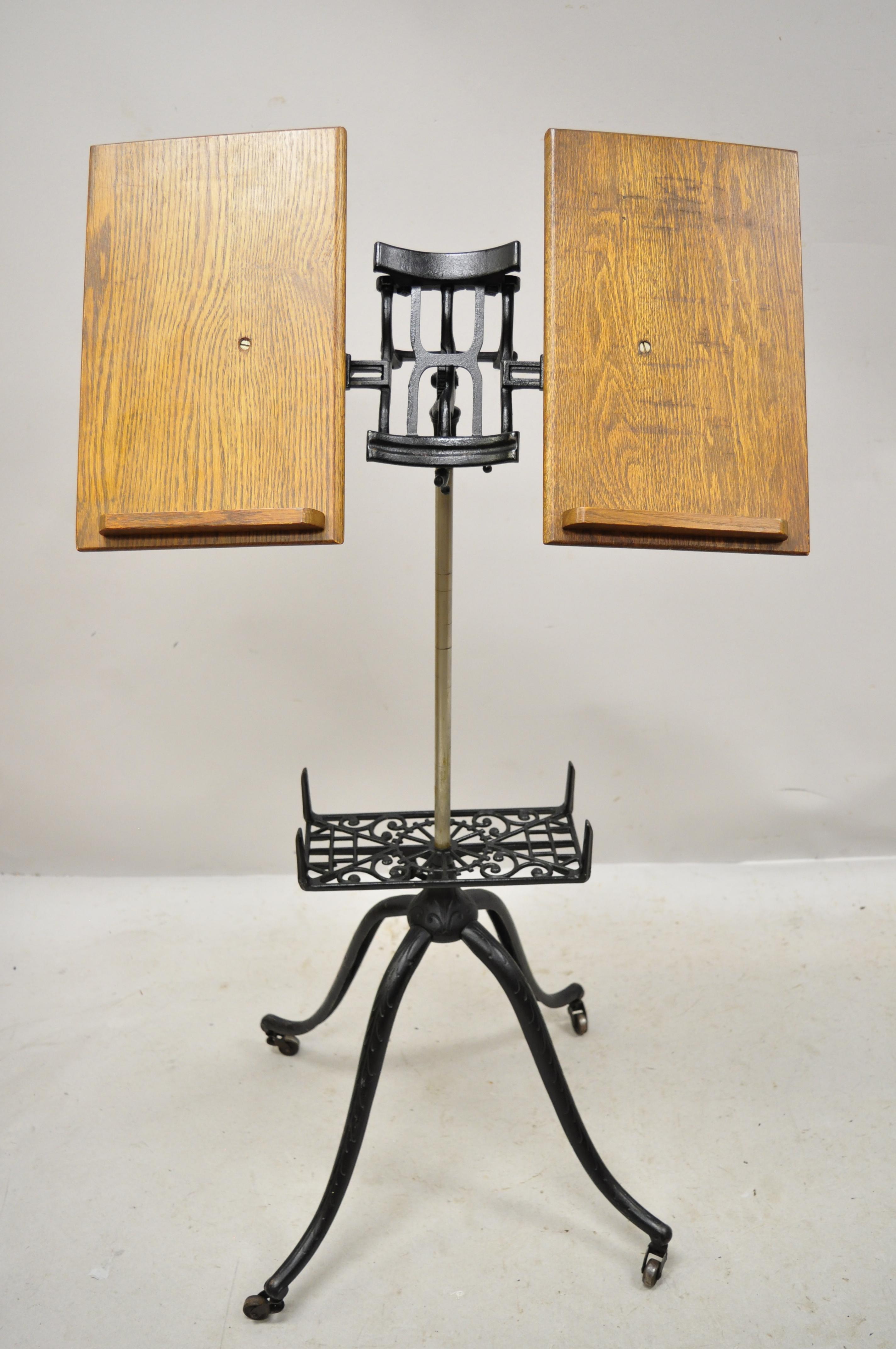 Antique English Victorian cast iron and oakwood book stand lectern bible holder. Item features oakwood book stands, rolling cast iron base. Height does not adjust, circa late 19th century. Measurements: 45