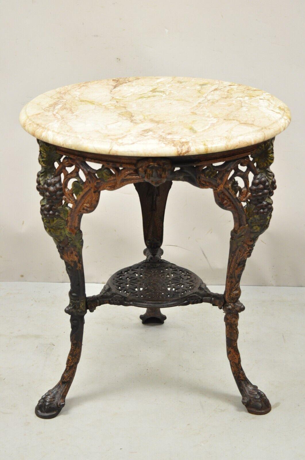 Antique English Victorian cast iron round marble top pub table. Item features lion heads, grape vine details, round marble top, heavy cast iron base, very nice antique item. Circa early 1900s. Measurements: 29