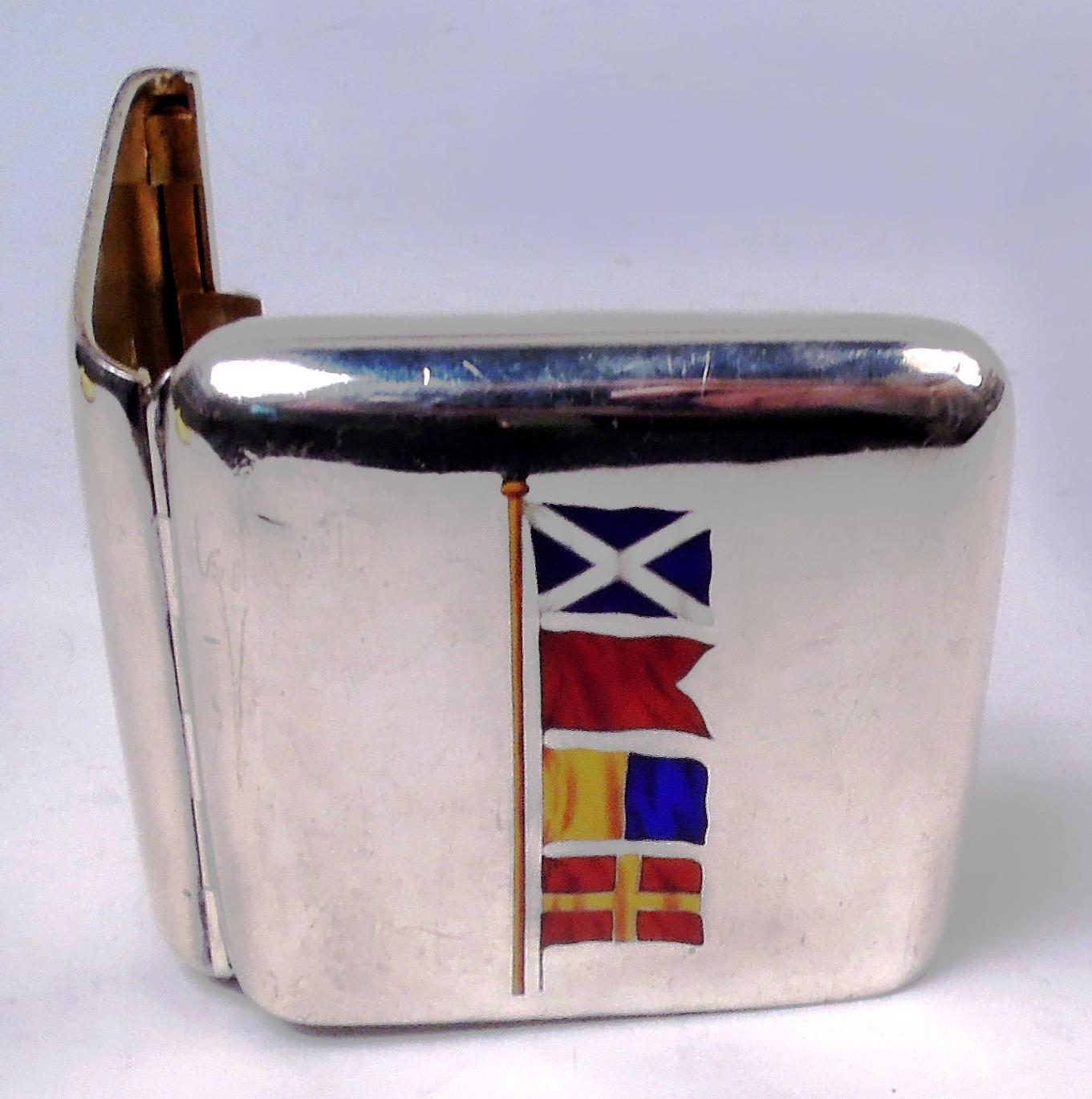 Victorian sterling silver cigarette case. Made by George Unite in London in 1894. Rectangular and hinged with push tab. Vermeil interior. On cover are enameled nautical signal flags with meanings that include “I am stopped” and “Desire to