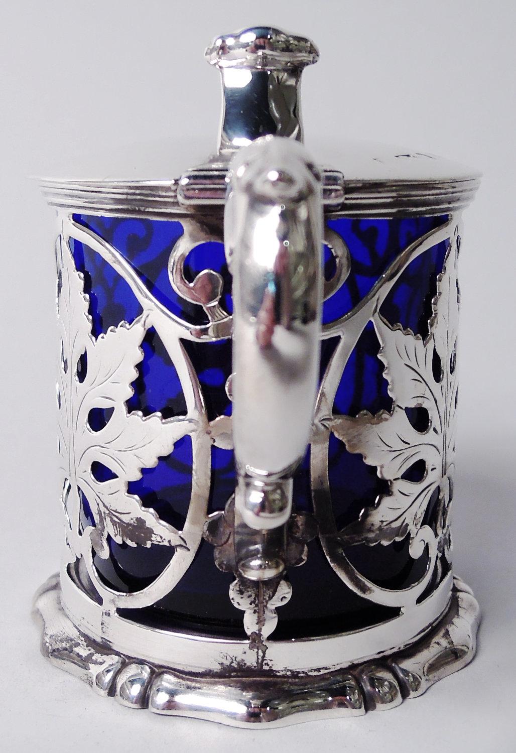 Tarro de mostaza clásico victoriano de plata de ley. Fabricada por Henry Wilkinson & Co. en Sheffield en 1842. Laterales abiertos con marcos de volutas con hojas incrustadas y racimos de uvas colgantes. Asa de doble vuelta con tapa de hoja y pie con