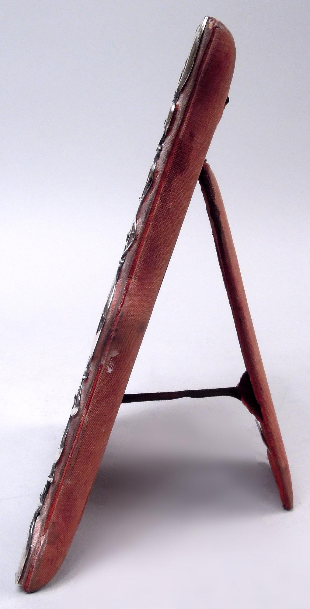 Cadre classique victorien en argent sterling, 1899. Fenêtre rectangulaire dans un encadrement de rinceaux ouverts ; en haut, cartouche massif à volutes (vacant) ; monture en velours. Verre biseauté, doublure en soie, dos en tissu et support de