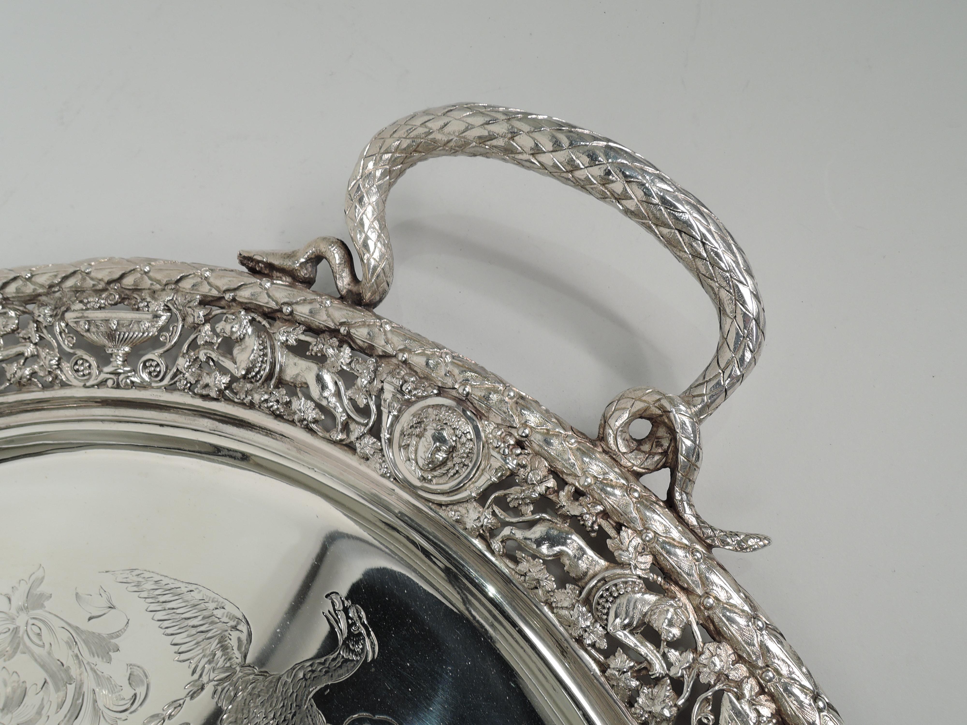 Victorian Classical sterling silver tea tray. Made by Stephen Smith in London in 1876. Oval well engraved with wreath comprising 4 eagles bestriding leafing scrollwork; center vacant. Cast open shoulder with leaping leopards, heads set in