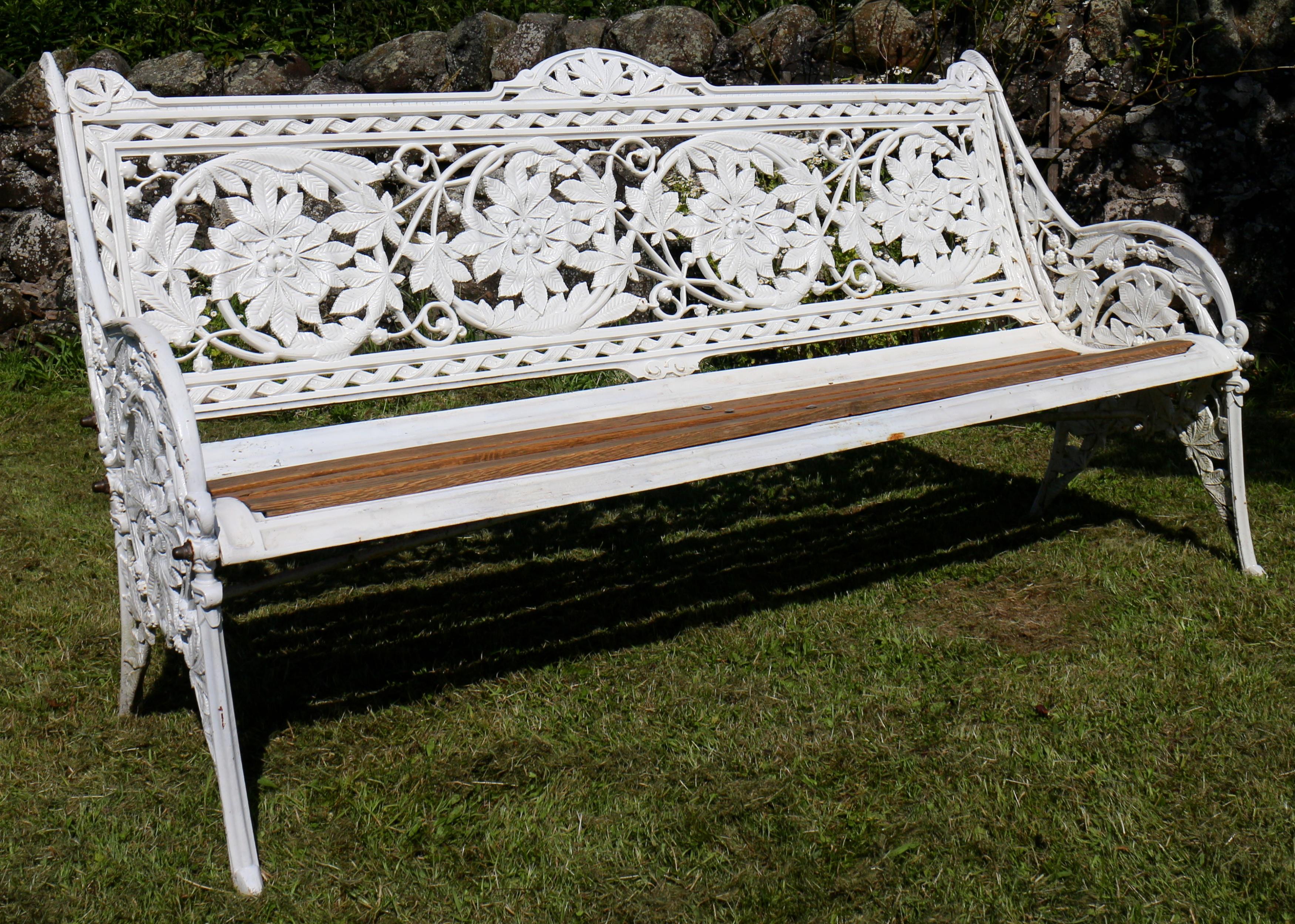 A Coalbrookdale Horse Chestnut pattern cast iron garden seat or bench, circa 1870. The pierced back and sides with a scrolling design depicting horse chestnut leaves and fruits, with bronze nuts, metal seat frame and oak slats. Fully stamped