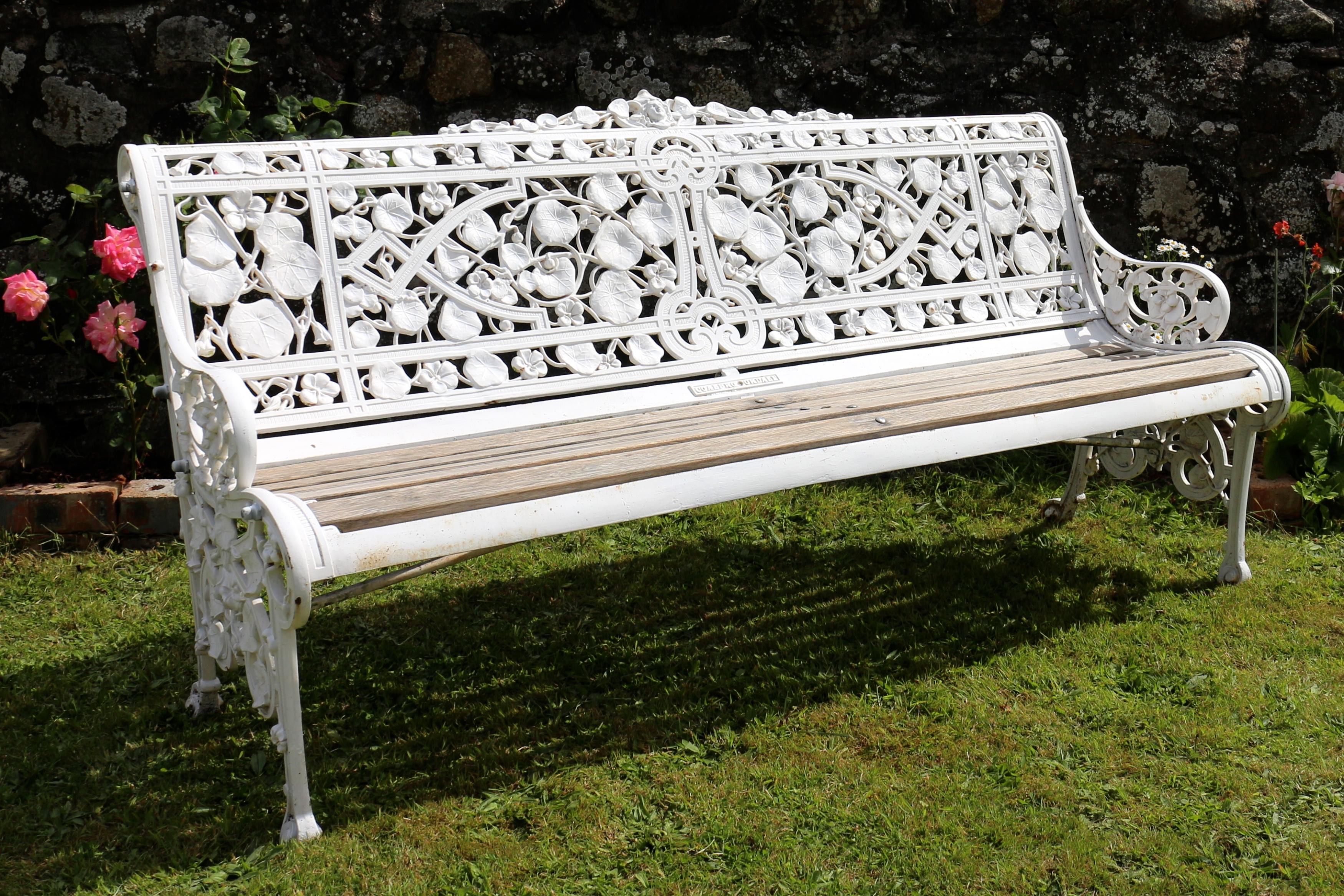A beautiful Coalbrookdale Nasturtium pattern cast iron garden seat or bench dating to circa 1870. The pierced back and sides with a naturalistic design of intertwined nasturtium leaves, flowers and seeds watched over by a classical mask. With bronze