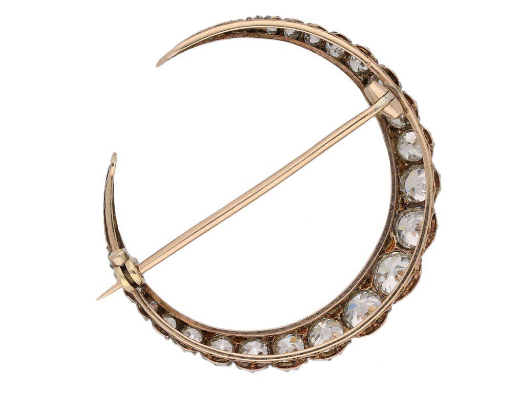 Antique diamond crescent brooch. Set with a round old cut diamond in an open back cut down setting with a weight of 0.60 carats, further set with twenty round old cut diamonds of graduating sizes in open back cut down settings with a combined weight