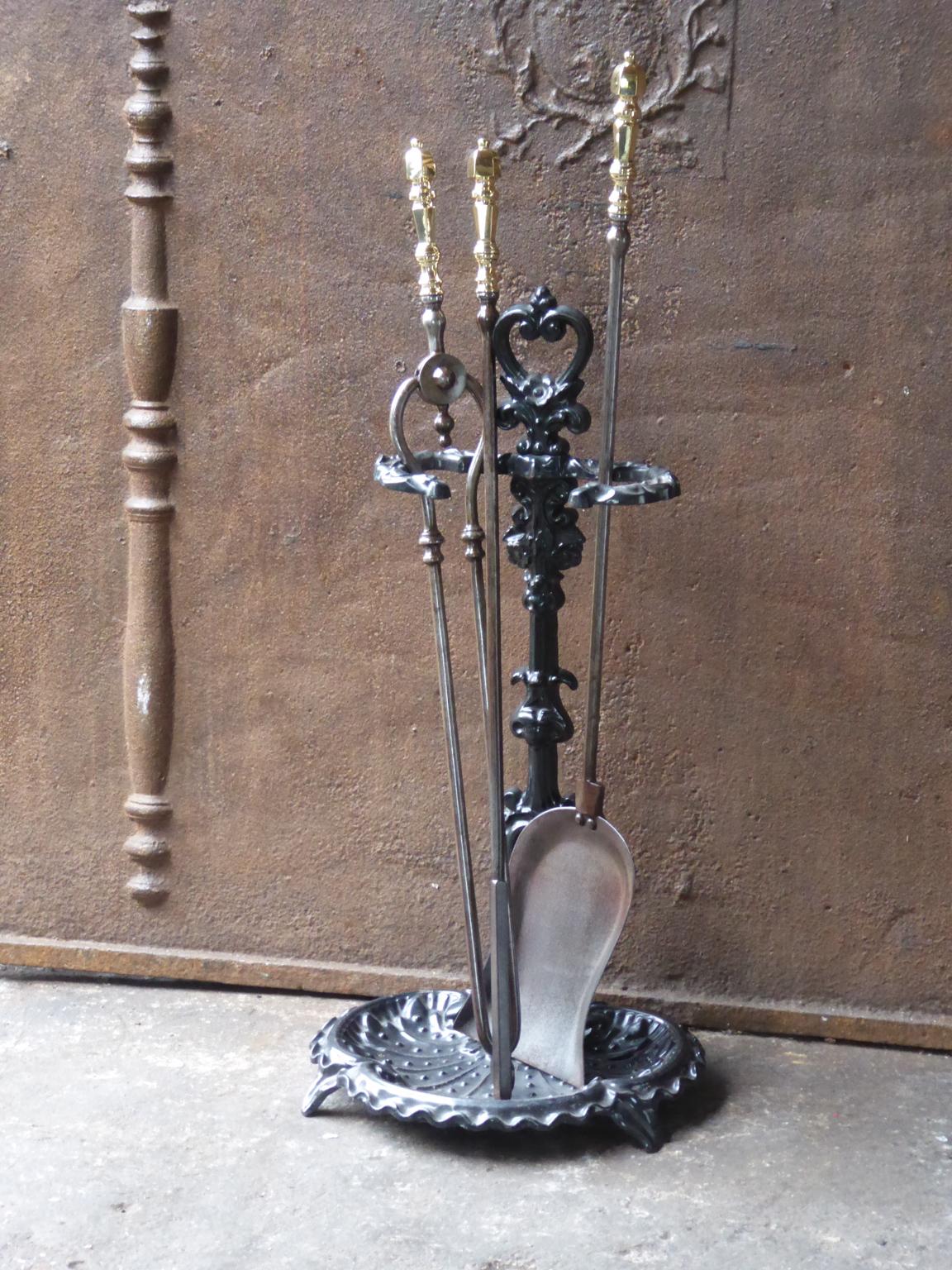 19th century English Victorian fireplace toolset consisting of a stand with three tools. The tools are made of wrought iron with polished brass handles. The stand is made of cast iron. The condition is good.













 