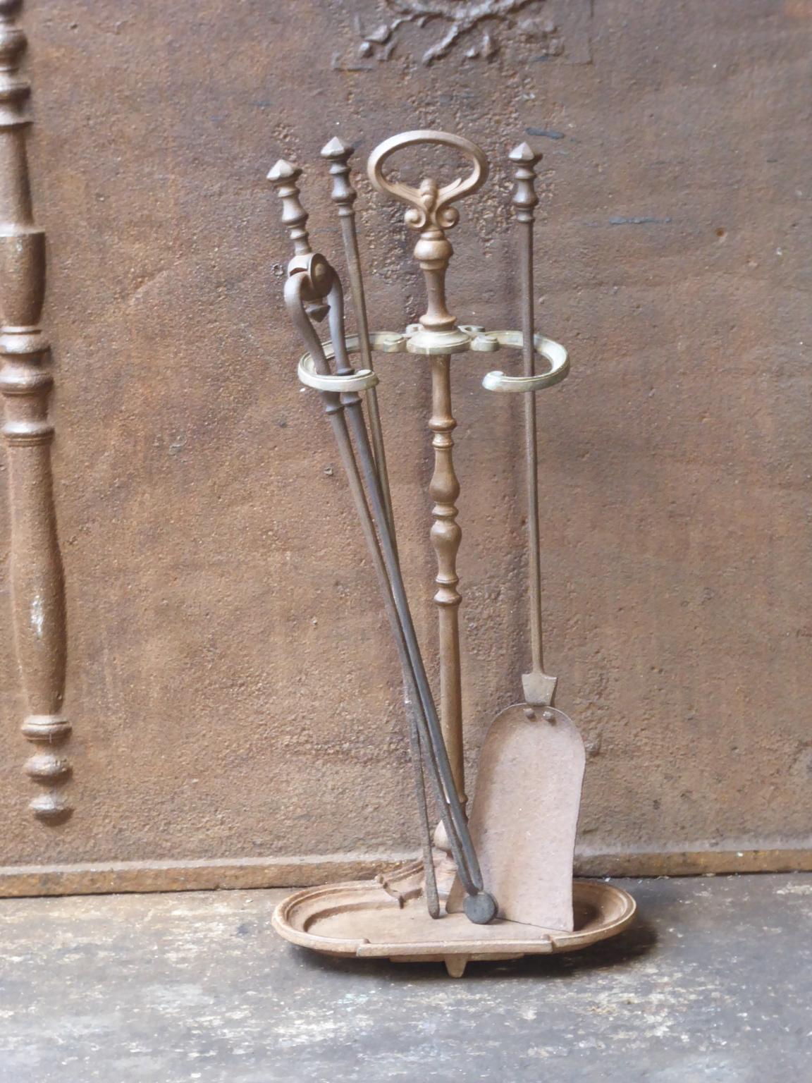 19th century English Victorian fireplace toolset made of cast iron, brass and wrought iron. The toolset consists of three tools and a stand. The condition is good.













 