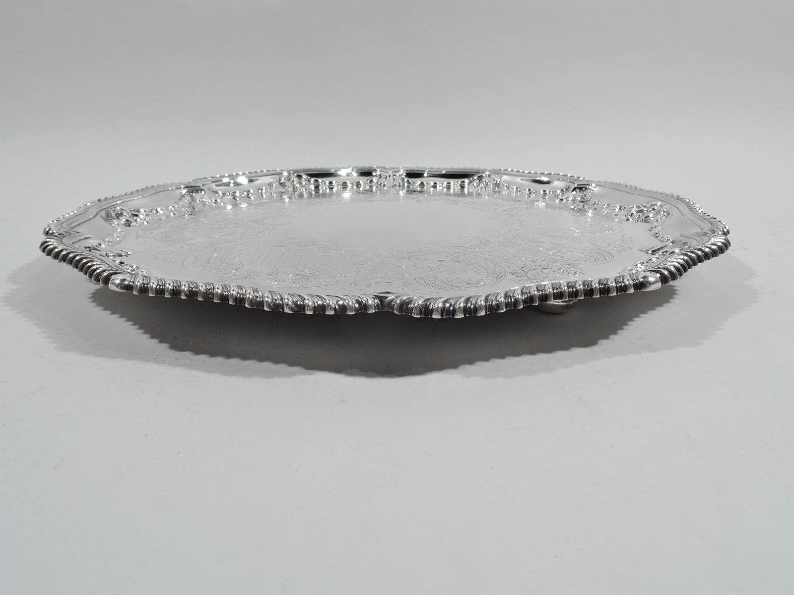 Victorian Georgian sterling silver salver. Made by Elkington in Birmingham in 1900. Well has vacant center surrounded by beautifully engraved scrolls, leaves, and flowers. Applied bud and seed garland interspersed with scallop shells on shoulder.
