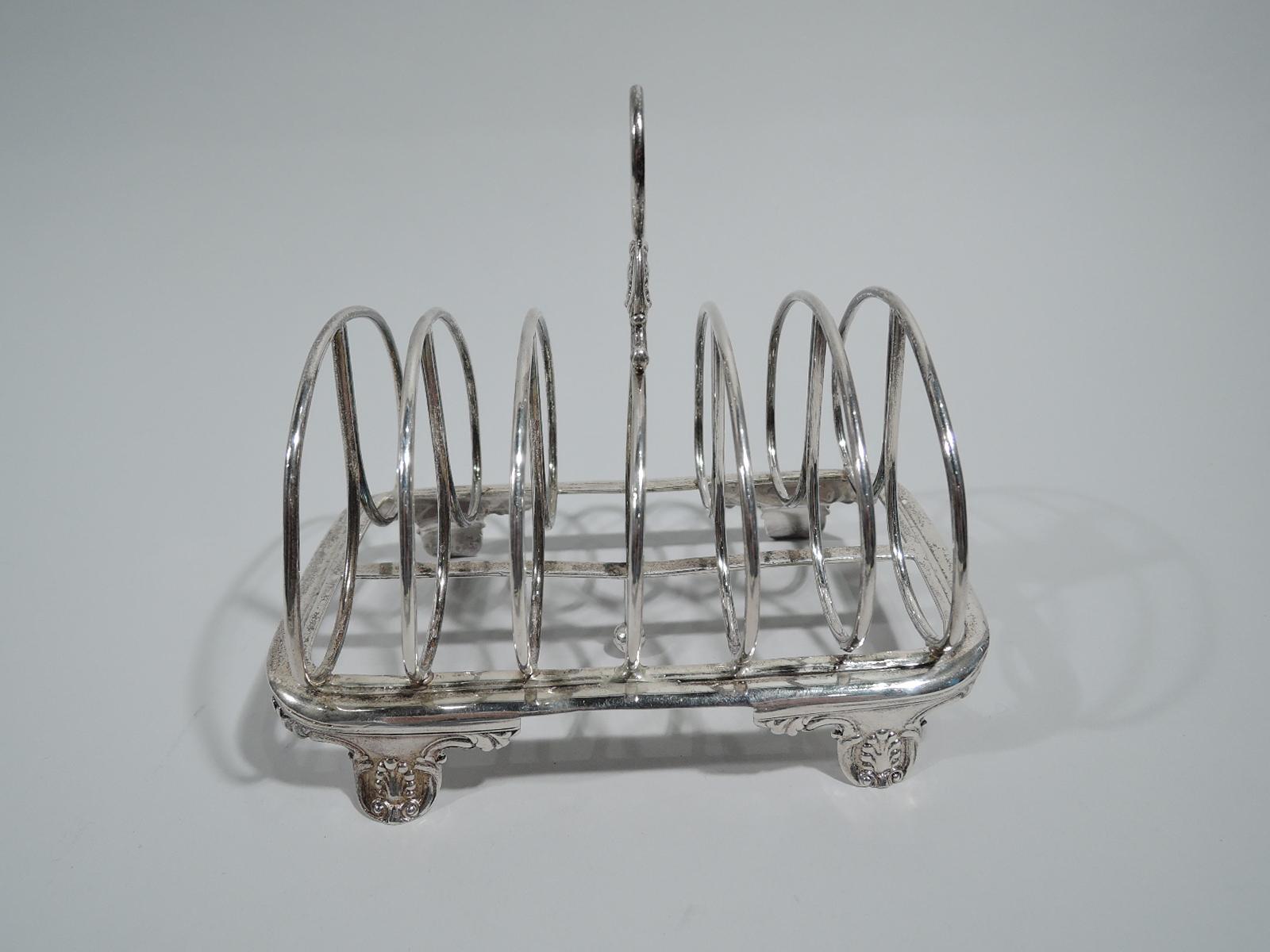 Victorian Georgian sterling silver toast rack. Made by Charles Thomas Fox in London in 1838. Seven double hoop partitions; central partition has ring handle with scroll and shell mount. Rectangular frame with curved corners and central partition; 4