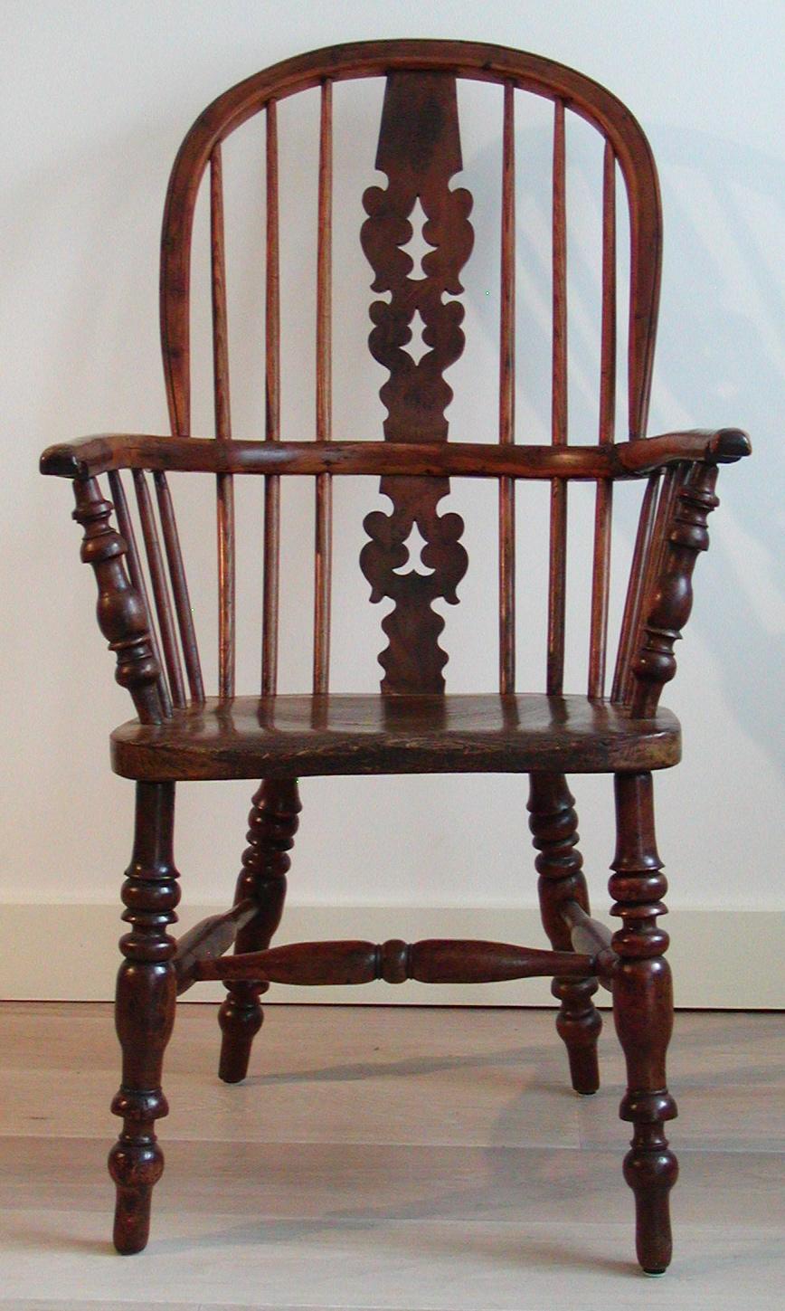Antique English Victorian large high-back Windsor armchair, crafted of yew, ash and elm, a fir-tree pierced shaped splat, the scroll-ended arms on baluster turned front supports, elm saddle seat, on triple ring turned legs joined by a crinoline