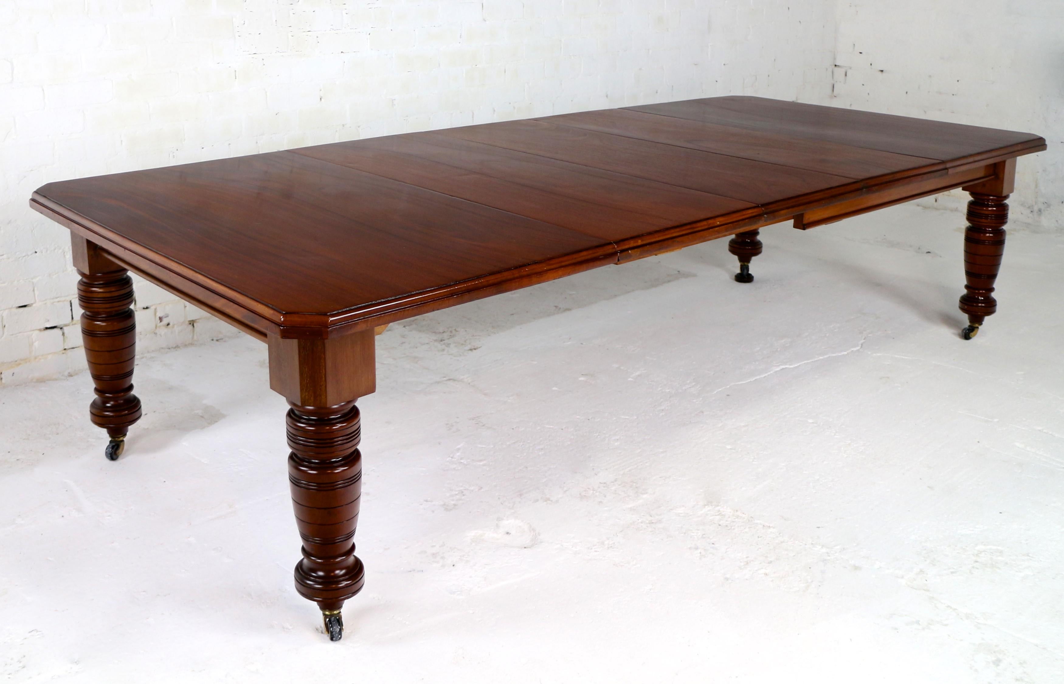 A superb Maple & Co Victorian wind-out extending dining table in solid mahogany and with three additional leaves and winding handle. Dating to circa 1890 it has a rectangular top with a moulded edge and canted corners and stands on four ring turned