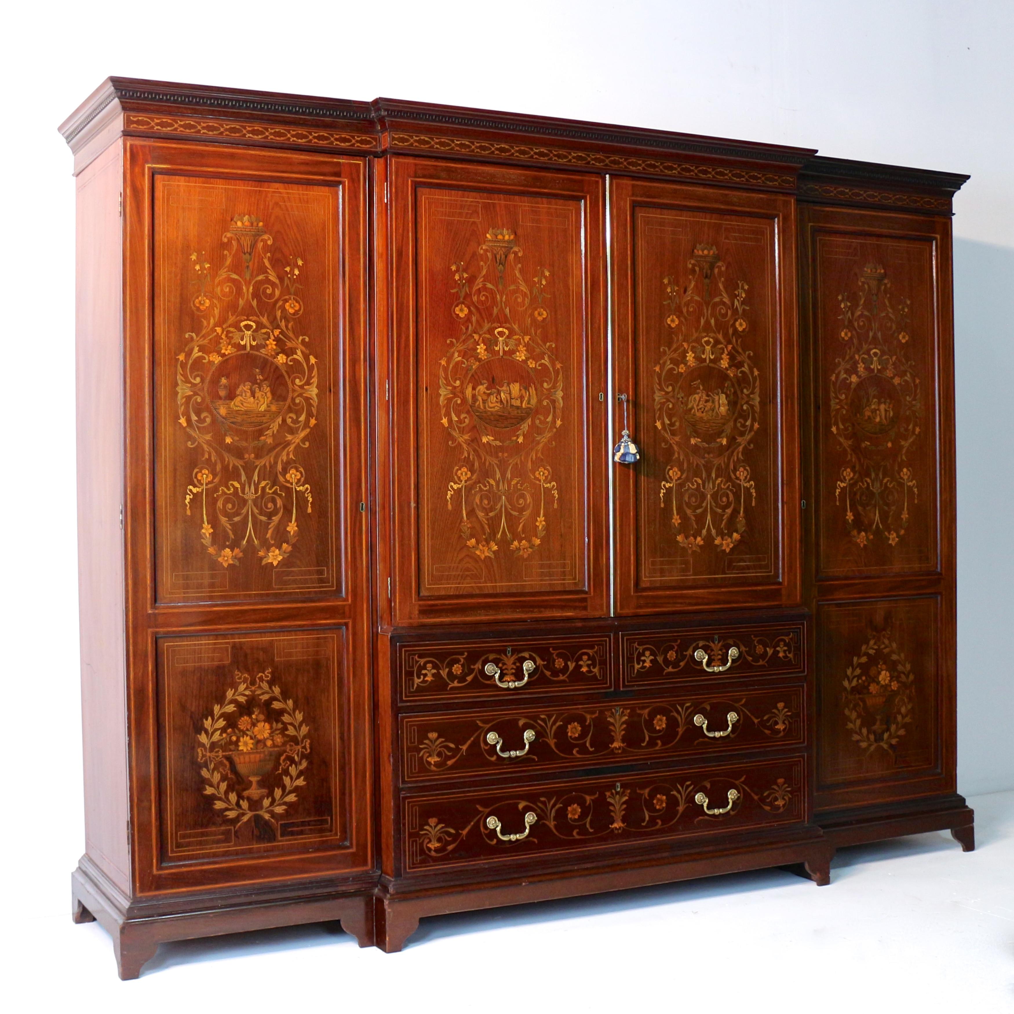 A stunning Sheraton Revival inlaid mahogany breakfront wardrobe dating to the early Victorian period and attributed to Edwards & Roberts.  Profusely decorated with fine quality ribbon tied trailing floral marquetry in veneers including satinwood and