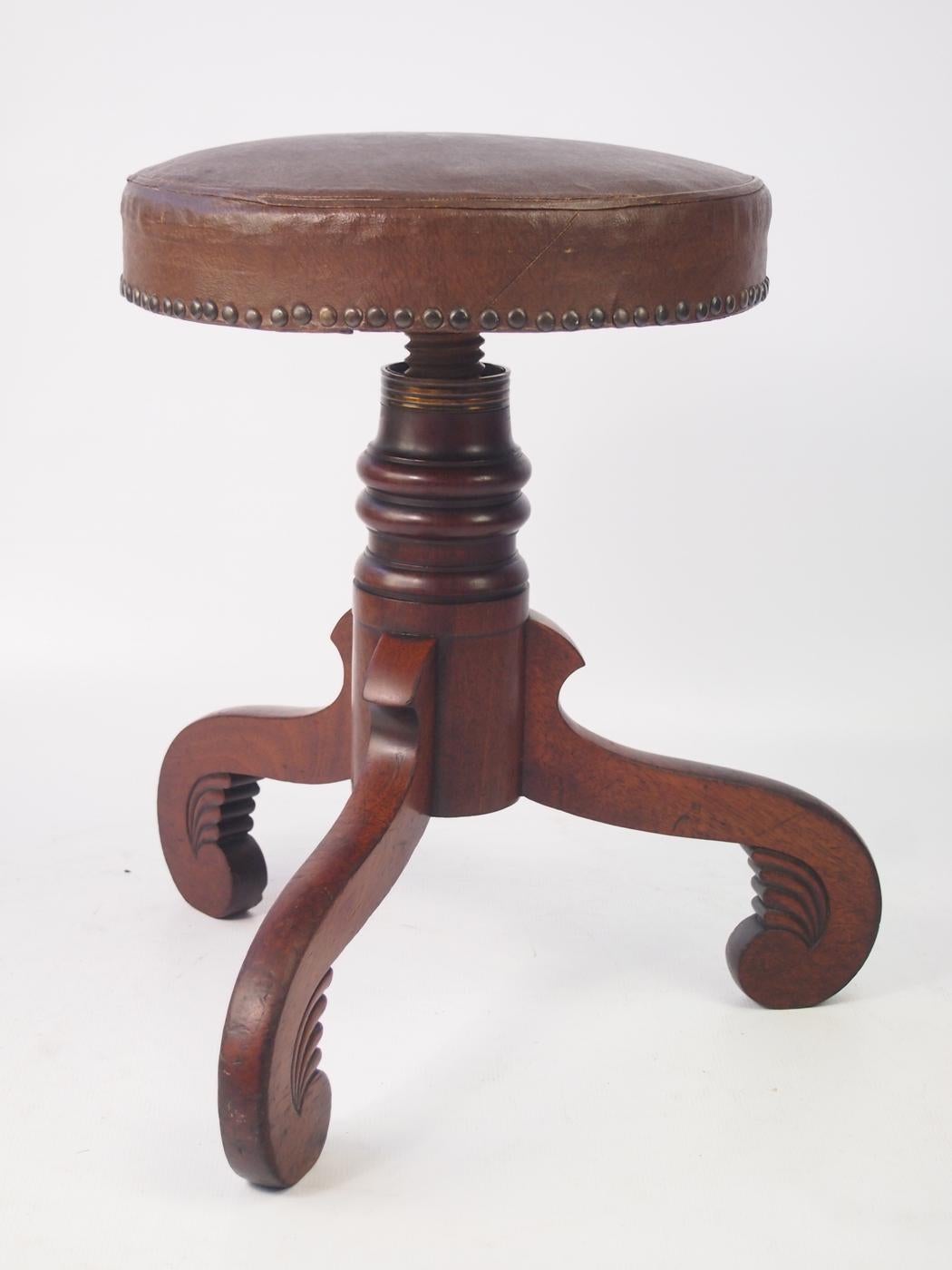 A handsome and rare antique early Victorian/ late Regency rise and fall piano stool in very good condition. A really stylish stool standing on an elegantly scrolled mahogany tripod legs with turned stem and carving to the feet. All original with