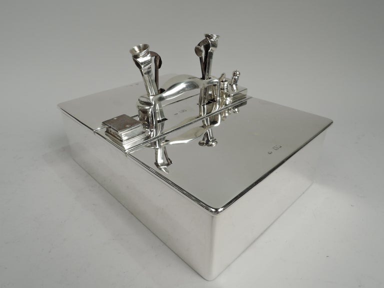 Victorian Modern sterling silver cigar box. Made by Joseph Braham in London in 1897. Rectangular with straight sides. Flat top with double hinged end covers. Center has scroll bracket handle; open rectangles at ends inset with detachable cutters.