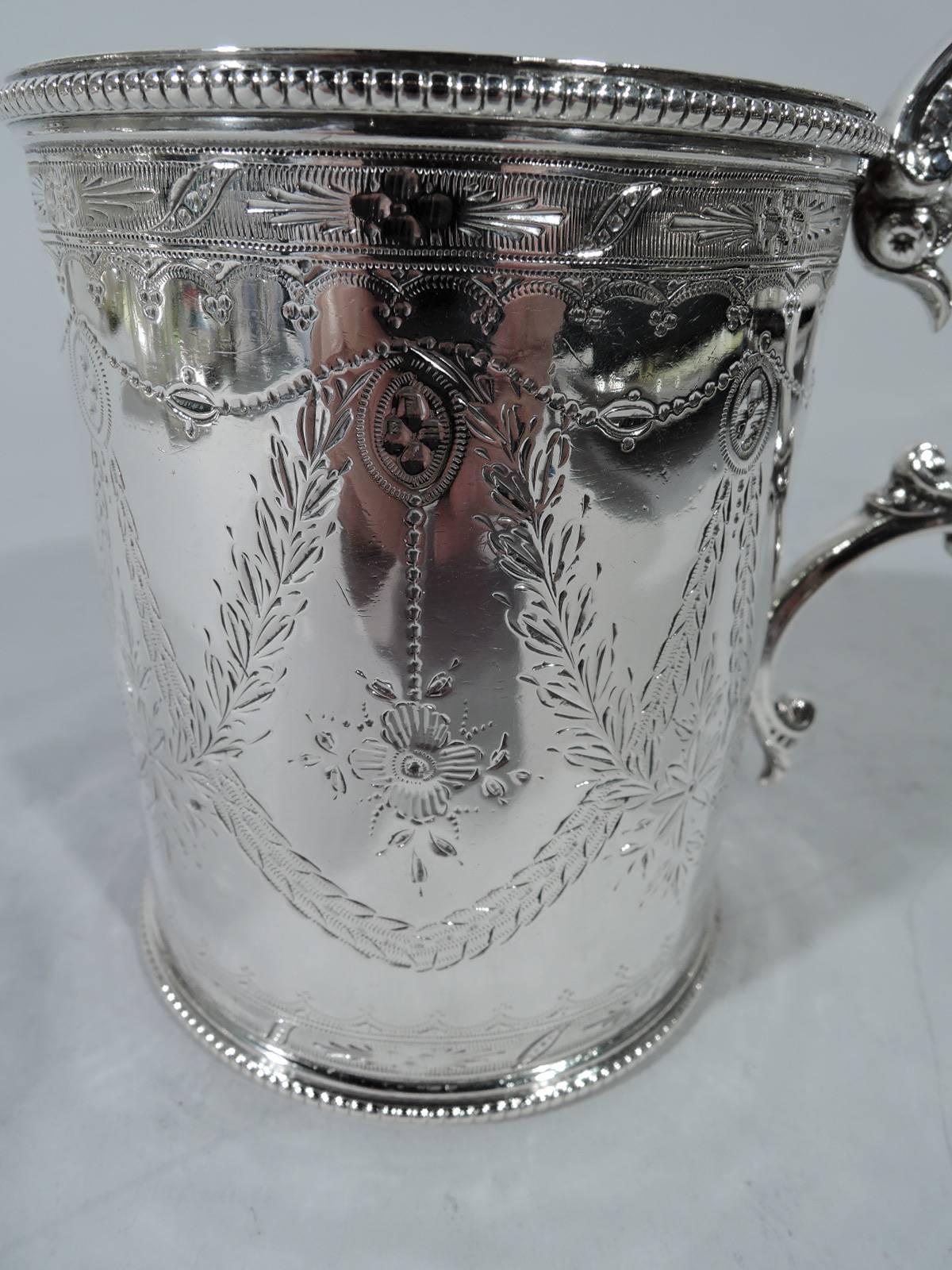 Victorian sterling silver baby cup. Made by Martin, Hall & Co. Ltd in Sheffield in 1866. Straight sides and scroll-capped beaded double-scroll handle. Paterae with pendant flowers and crisscrossing garlands. Beaded rims. Pretty neoclassical