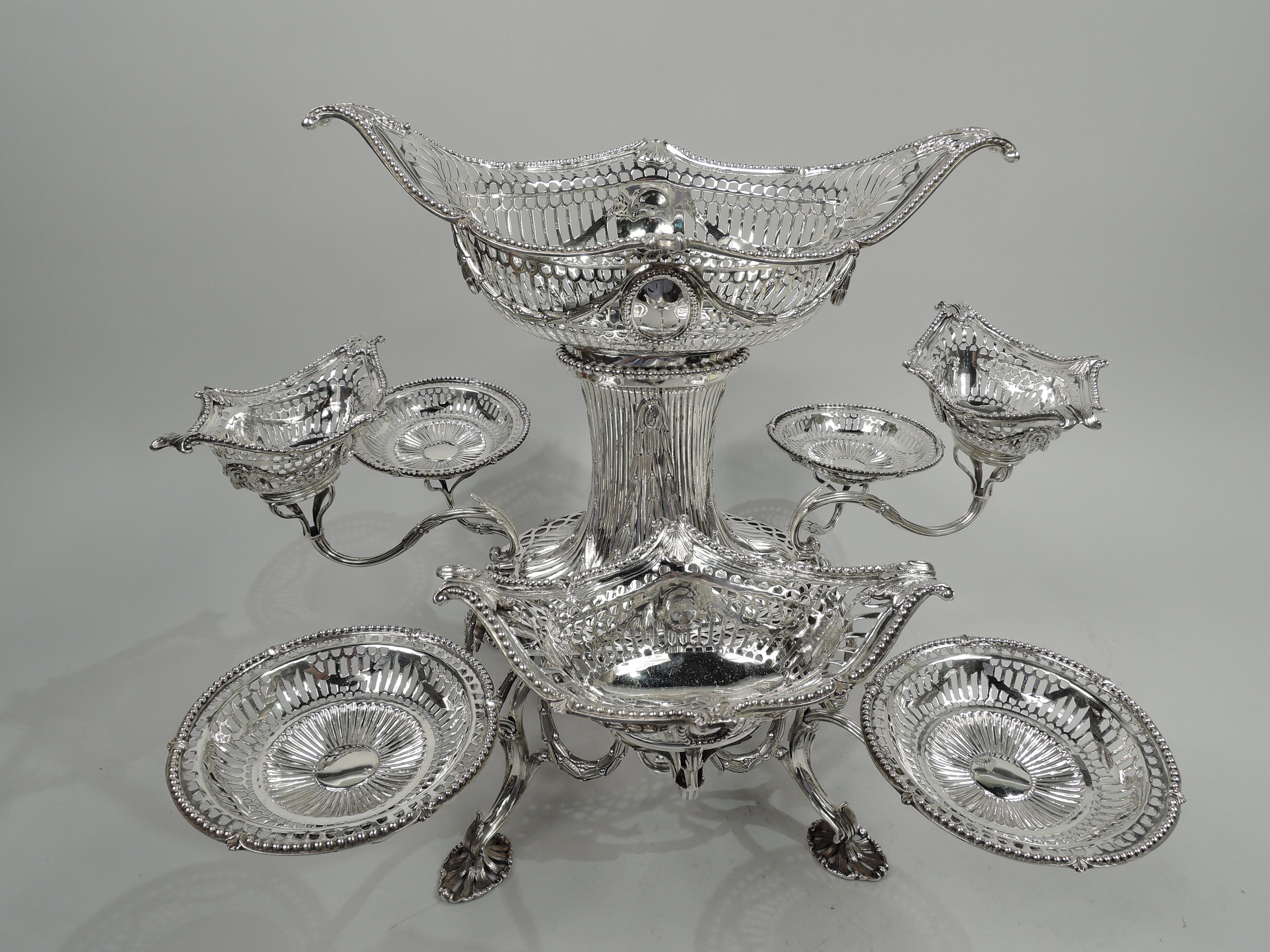 Victorian neoclassical sterling silver epergne. Made by Charles Stuart Harris in London in 1895. Central oval frame with pendant leaf garland threaded through fixed rings and supporting oval medallions with amphorae applied to stippled ground. Frame