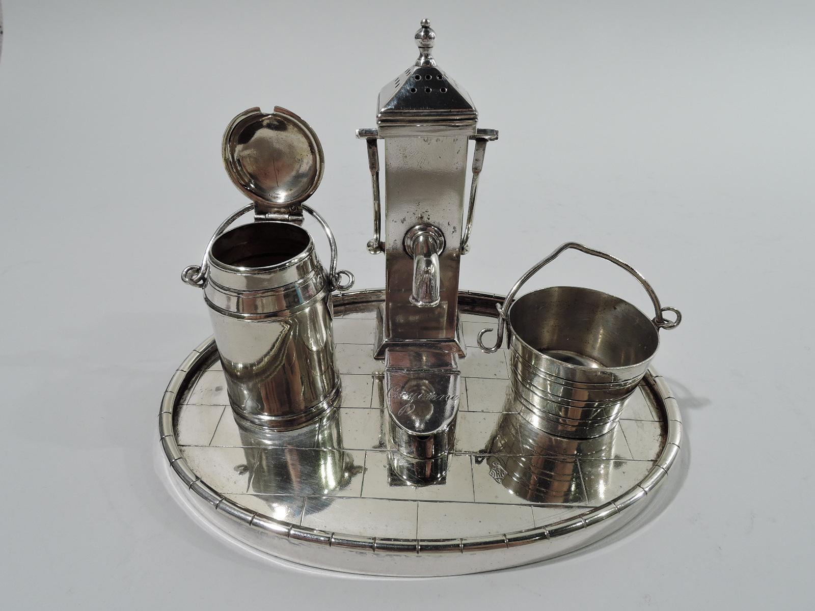 English Victorian silver-plated novelty condiment set, ca 1872. Oval base with “bricked” floor mounted with water-pump pepper shaker: Rectilinear shaft with pierced and faceted cover and ball finial set in same shaft with 2 fixed handles and spout.