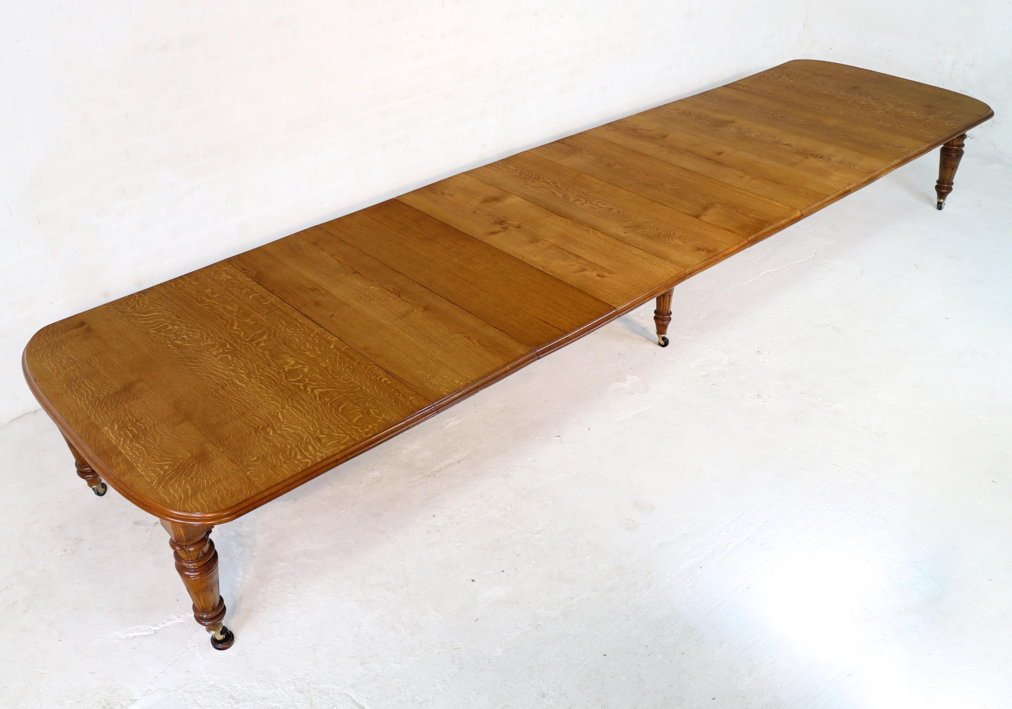 A large Victorian extending dining table in golden quarter-sawn oak and with eight leaves and winding handle. Dating to c.1860 this 56in wide table smoothly extends from 6ft 7in to 18ft 1in using a Joseph Fitter double screw winding mechanism