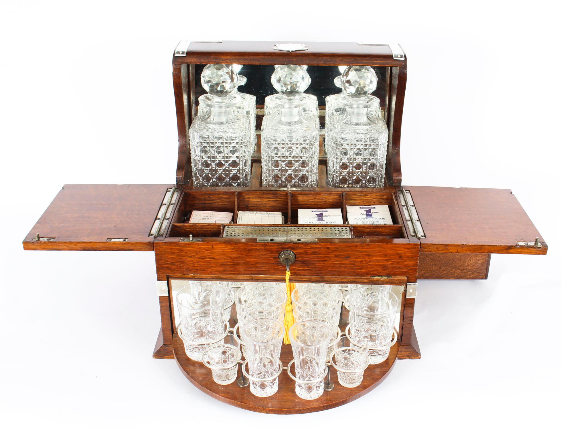 This is a superb antique Victorian oak cased three decanter tantalus with decorative silver plated cut brass mounts and carry handles to the sides, circa 1870 in date.

This magnificent tantalus features three wonderful hobnail cut square