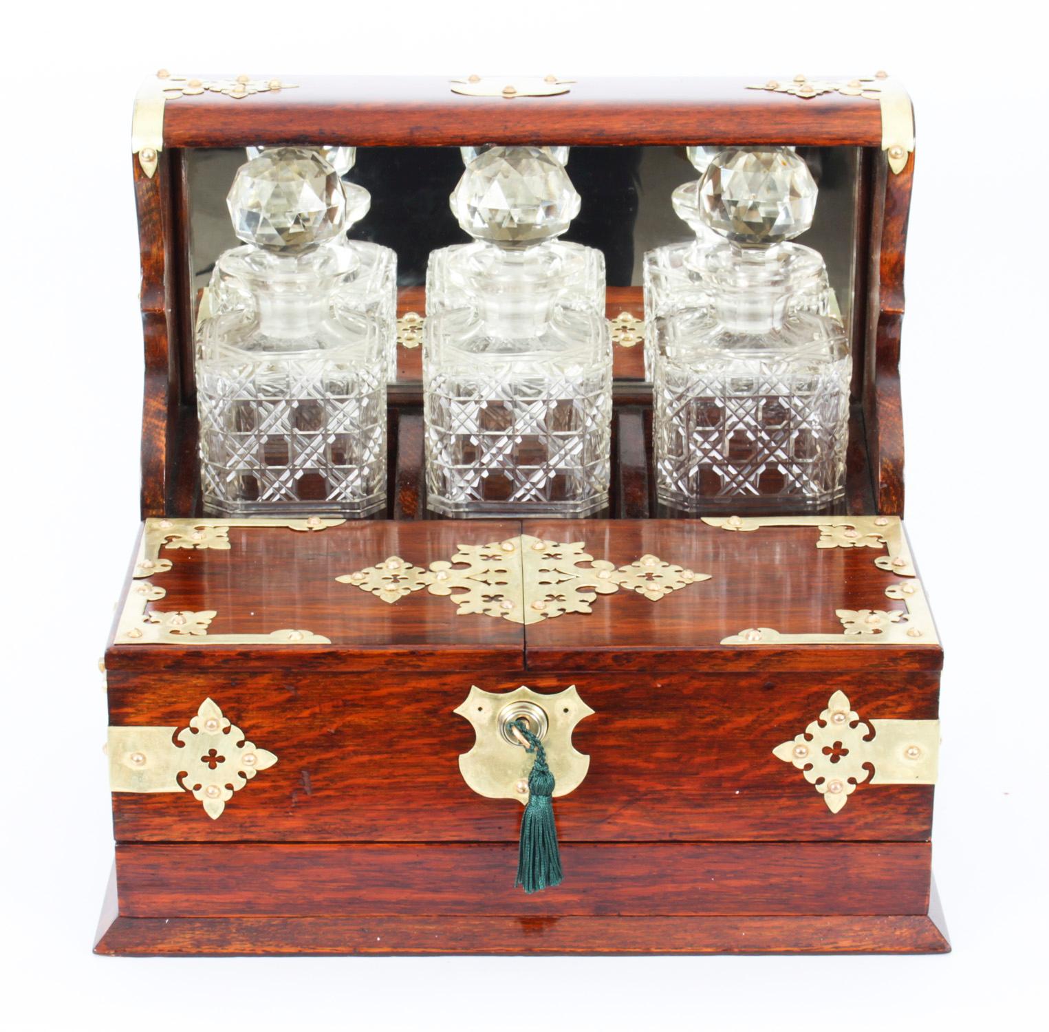 This is a superb antique Victorian oak cased three decanter tantalus with decorative silver plated cut brass gothic revival mounts and carry handles to the sides, circa 1880 in date.

This magnificent tantalus features three wonderful hobnail cut