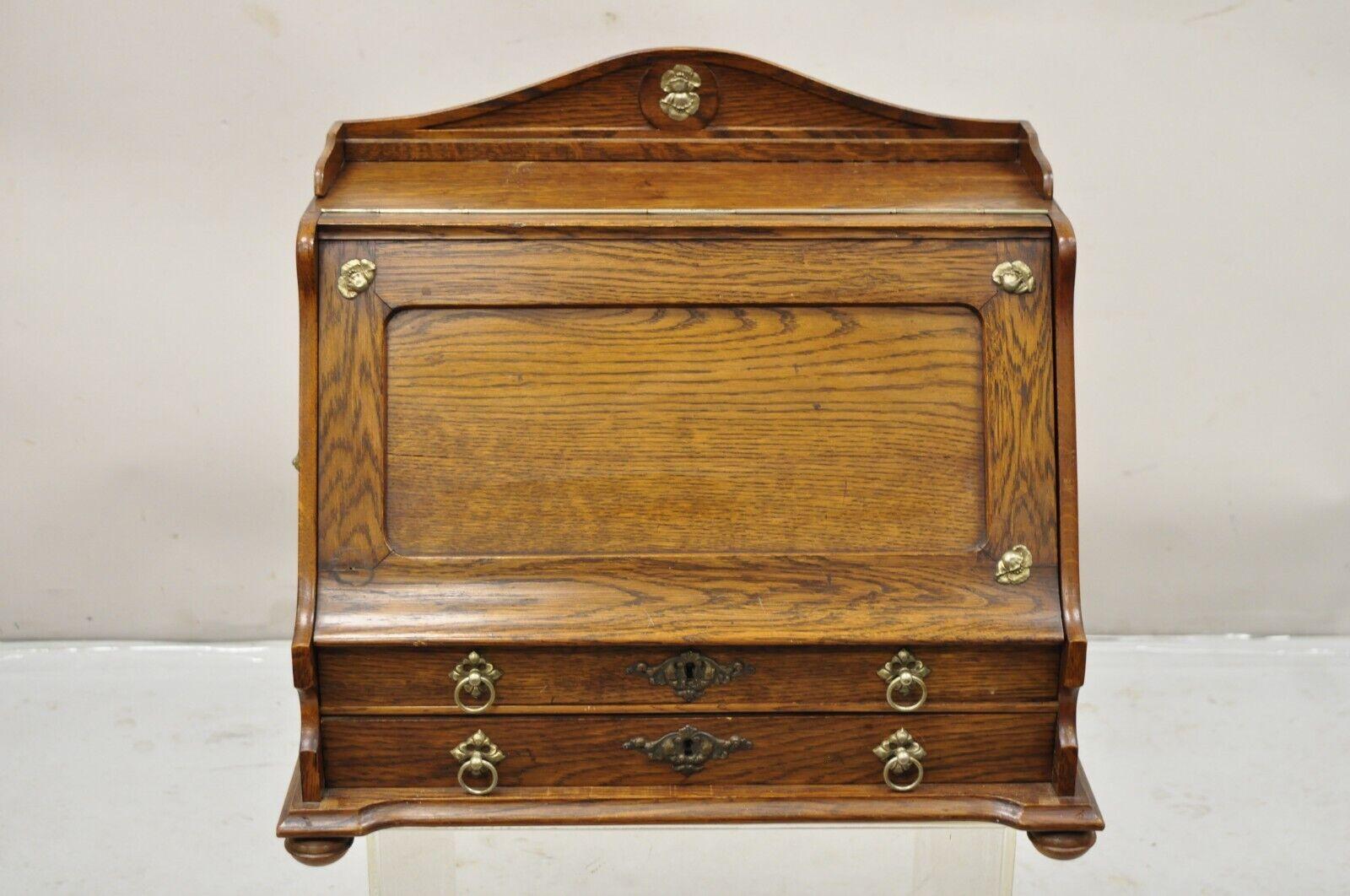 Antique English Victorian Oak Wood Desktop Lap Desk Letter Holder. Item features a lift front with fitted interior, small glass inkwell, lion head drop ring handles, raised on turn carved feet, solid wood construction, beautiful woodgrain, very nice