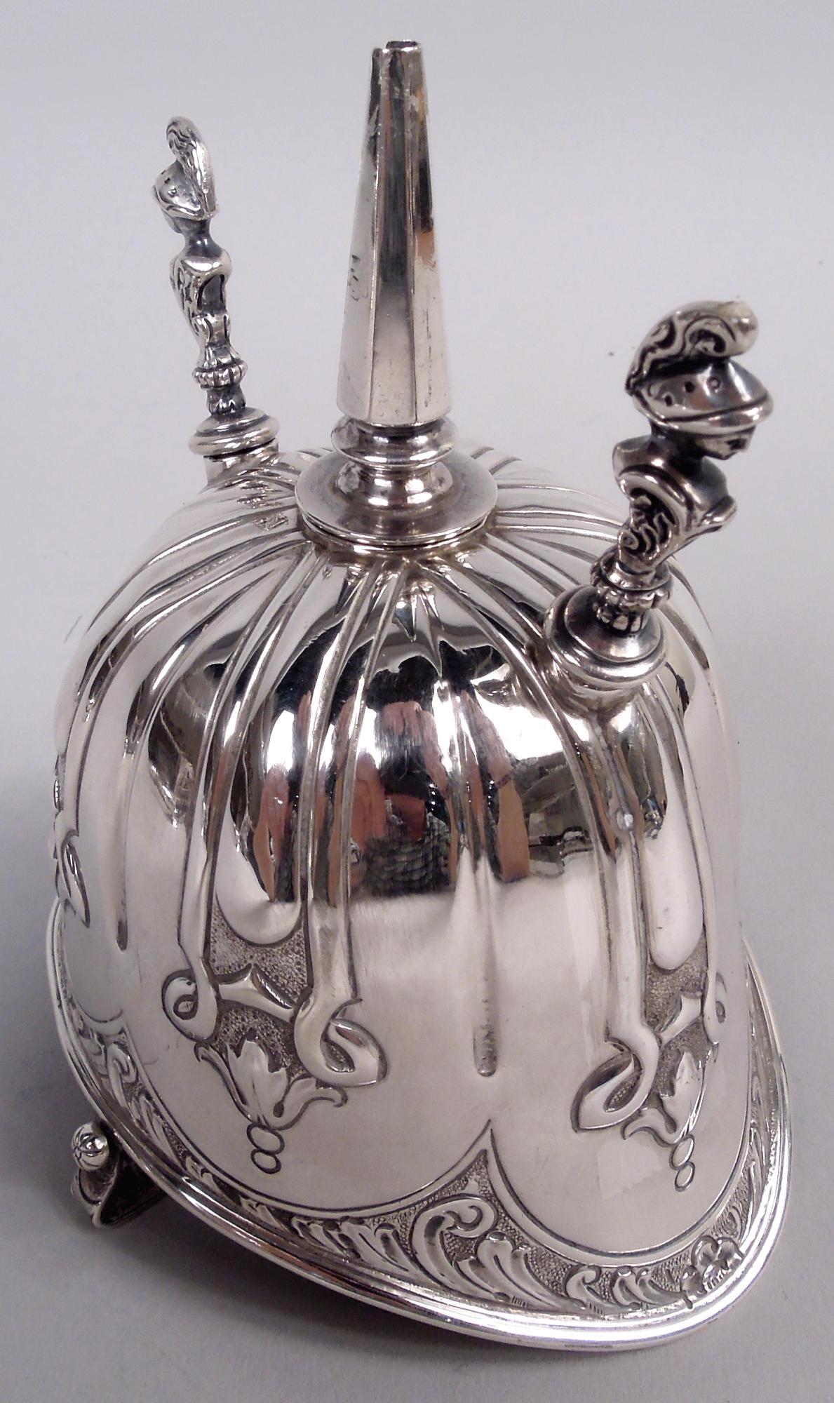 Accendisigari vittoriano in argento sterling. Prodotto da Samuel Walton Smith & Co. a Londra nel 1900. A forma di elmo di midollo; canna a spillo tra gli utensili con manici a busto classico. Un'ode all'impero che evoca i lontani ritmi tropicali.