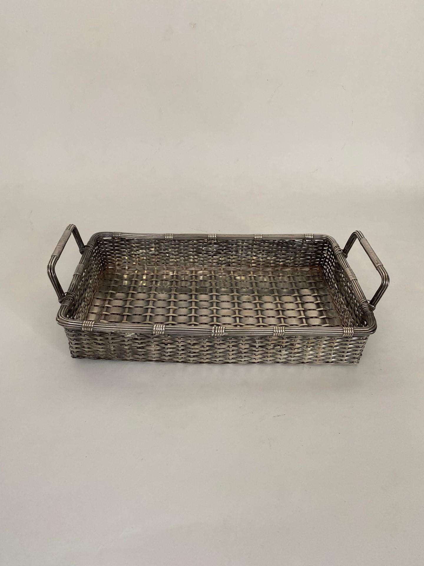 A  rare English made antique Victorian silver plate woven basket with two handles is a delightful and intricate piece that reflects the ornate design sensibilities of the Victorian era. This charming basket is crafted from silver-plated material,