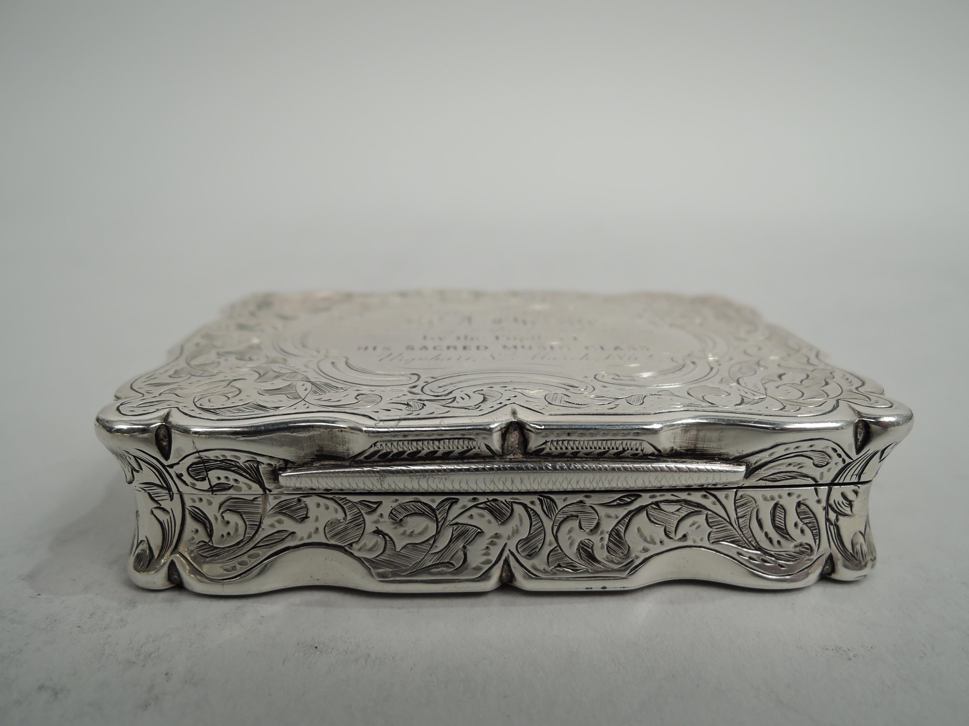 Victorian Classical sterling silver snuff box. Made by Frederick Marson in Birmingham in 1860. Rectangular with concave sides, curved corners, flat and hinged cover, and curvilinear rims. Densely engraved and shaded leafing scrollwork. On cover top