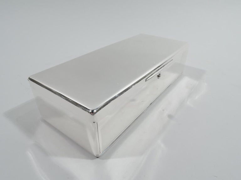 English Victorian sterling silver box, 1898. Rectangular with curved corners and push-button latch. Cover flat and hinged with tapering tab. Front also hinged. Gilt interior. Fully marked including London assay stamp and unidentified maker’s