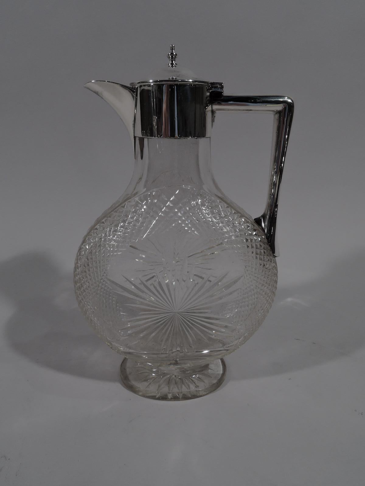 Victorian glass and sterling silver decanter. Made by Grinsell & Sons in London in 1899. Clear glass moon body with flat oval foot. Cut ornament: A star surrounded by diaper on front and back, and star on foot underside. Sterling silver collar with