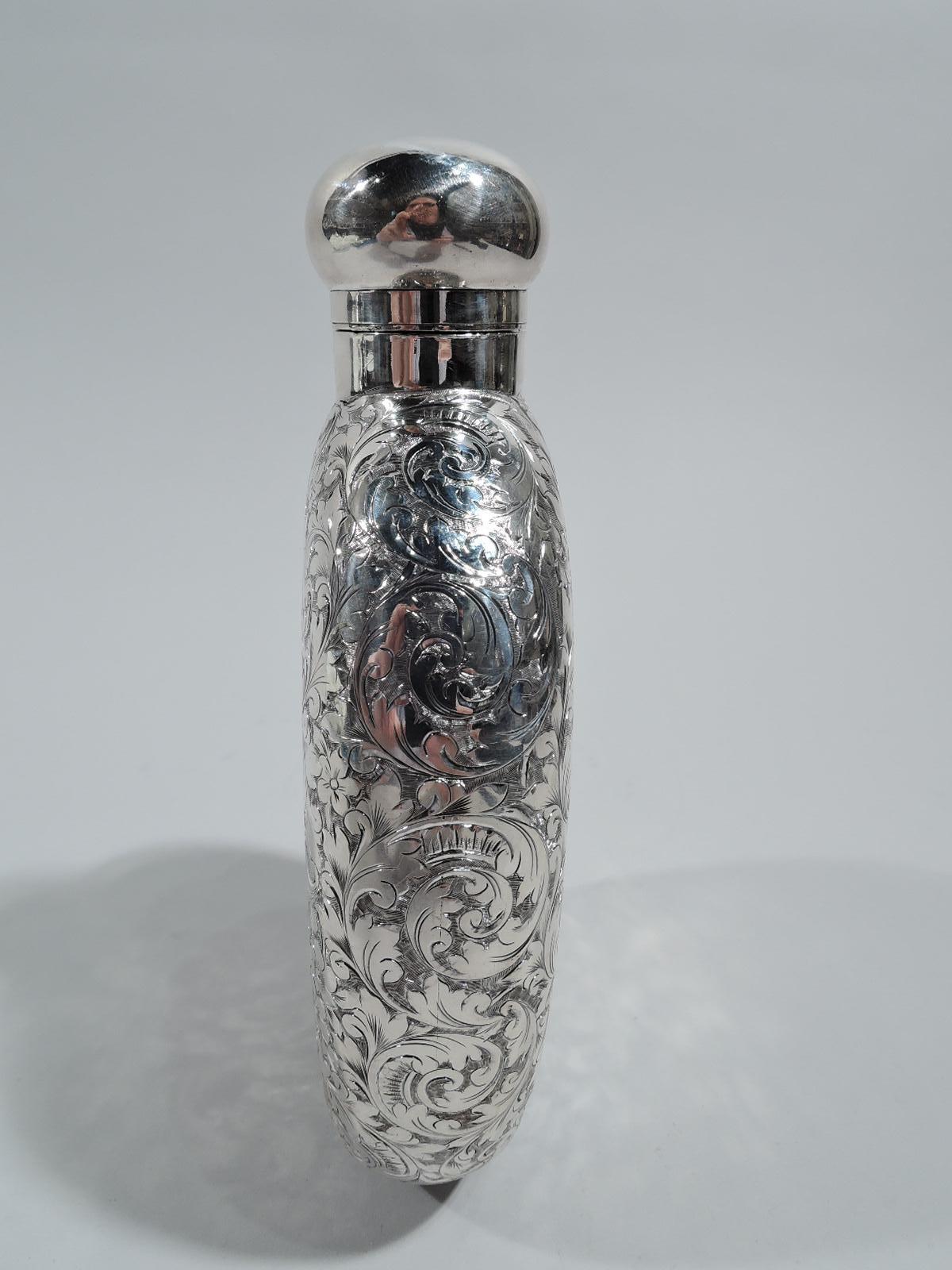 Victorian sterling silver flask. Made by Elkington & Co. in Birmingham in 1892. Ovoid with flat sides. Dense and allover leafy scrolls. On front armorial frame engraved with interlaced monogram. Hinged and cork-lined ball cover. Fully marked.
