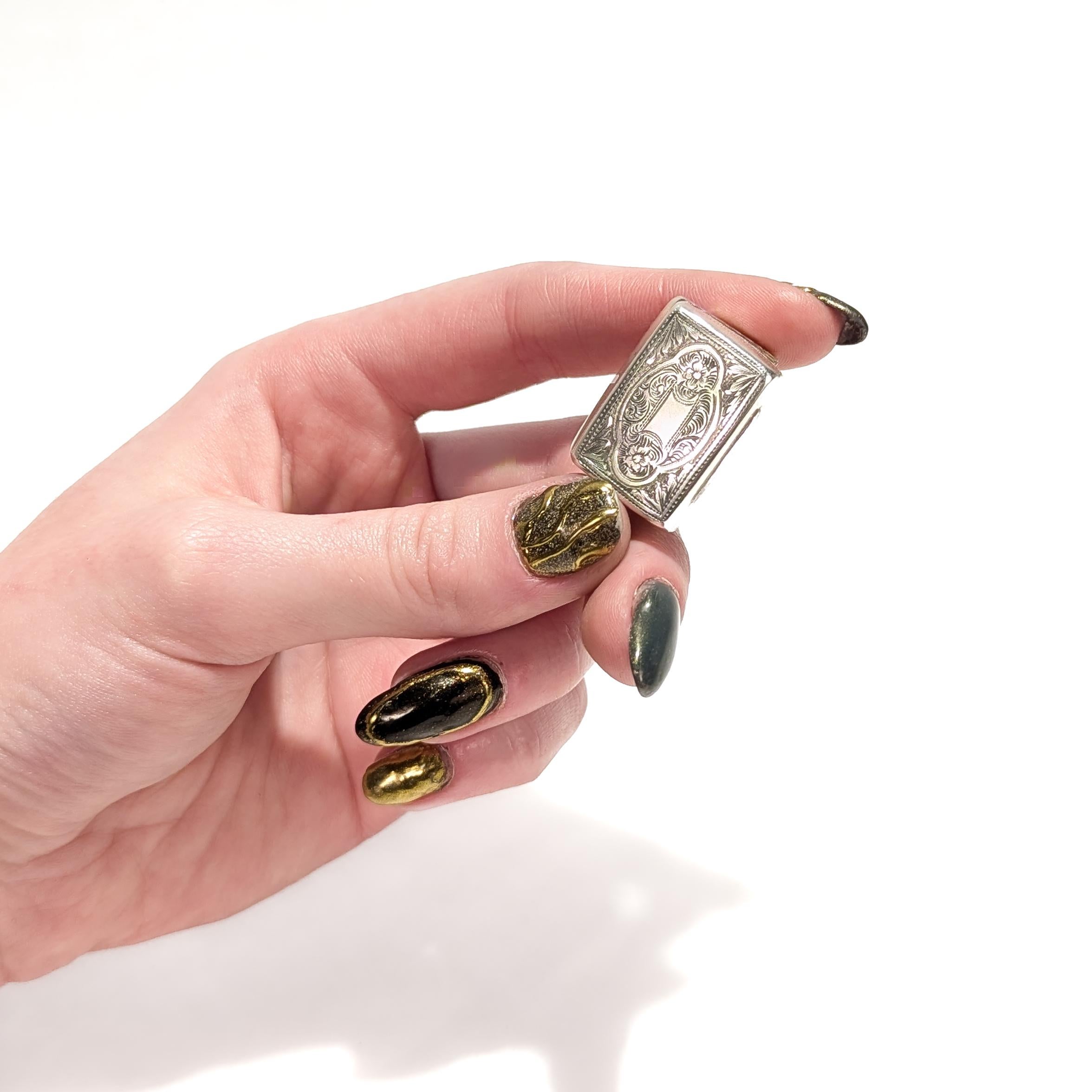 A fine Victorian vinaigrette.

In sterling silver.

By Edward Smith of Birmingham.

With engraved decoration to the body, a pierced grille hinged to the side, and a gilt interior. 

The vinaigrette even retains an early sponge.

Fully hallmarked for